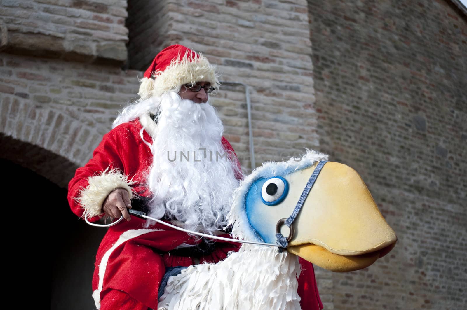 Santa Claus riding a fake ostrich.