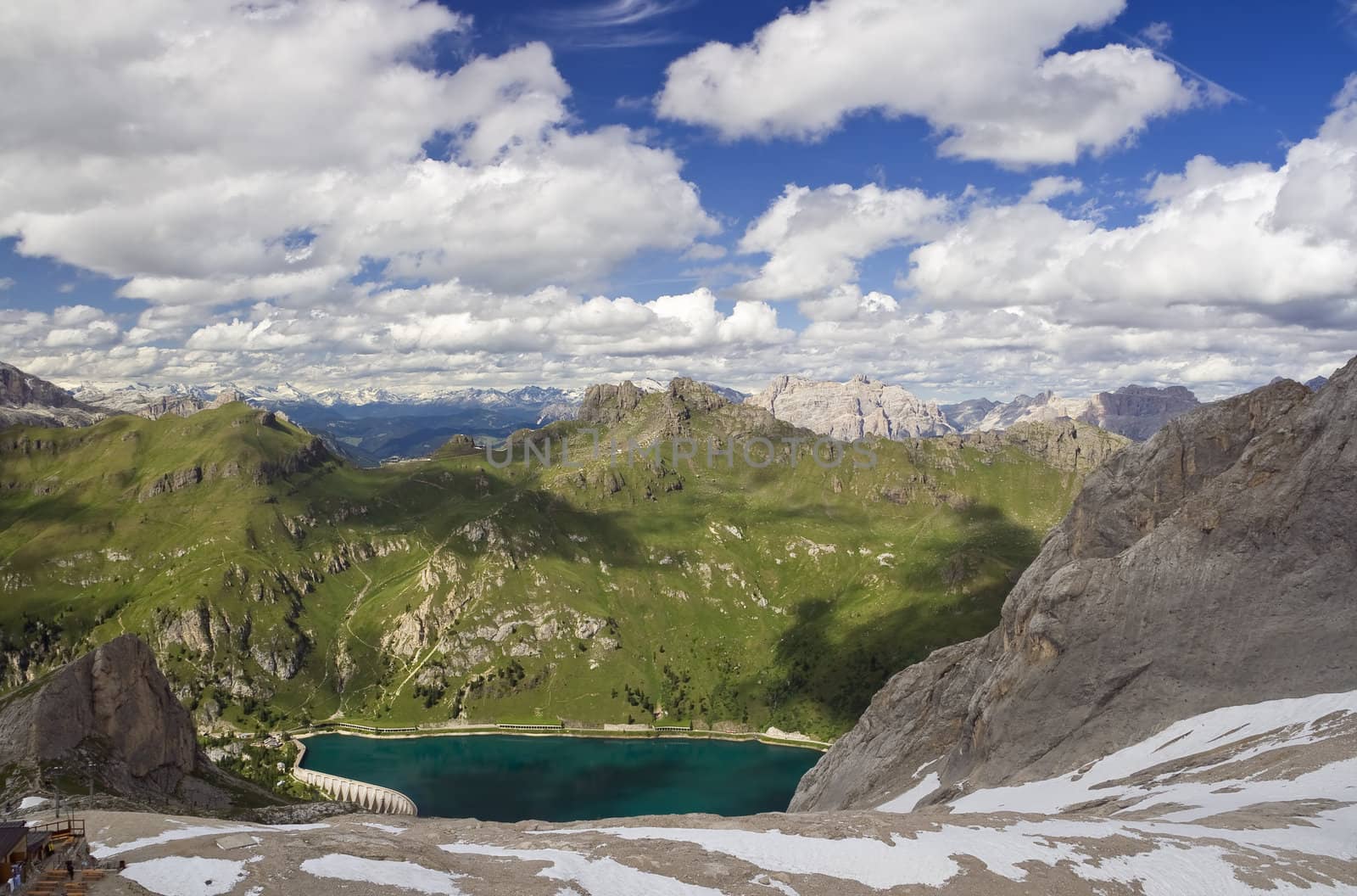 summer view of Fedaia lake and dolomites from Marmolada glacier, Trentino, Italy. Photo taken with polarizer filter