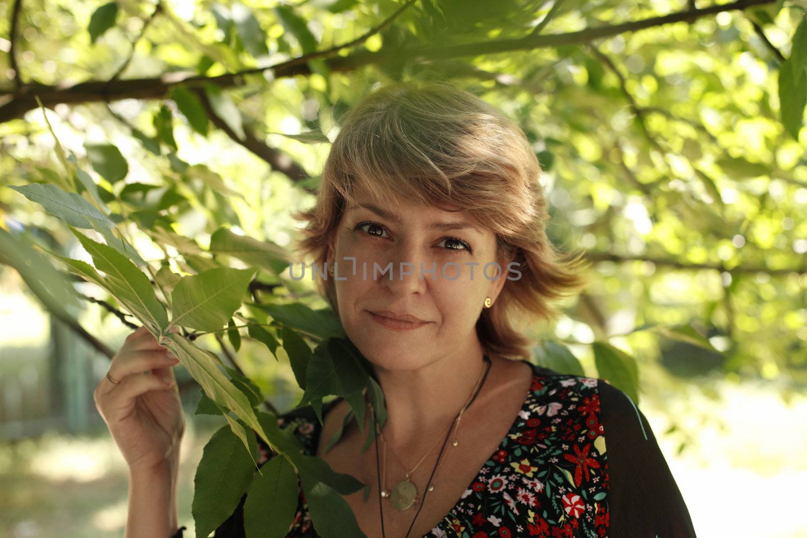 Portrait of the adult woman on a background of tree