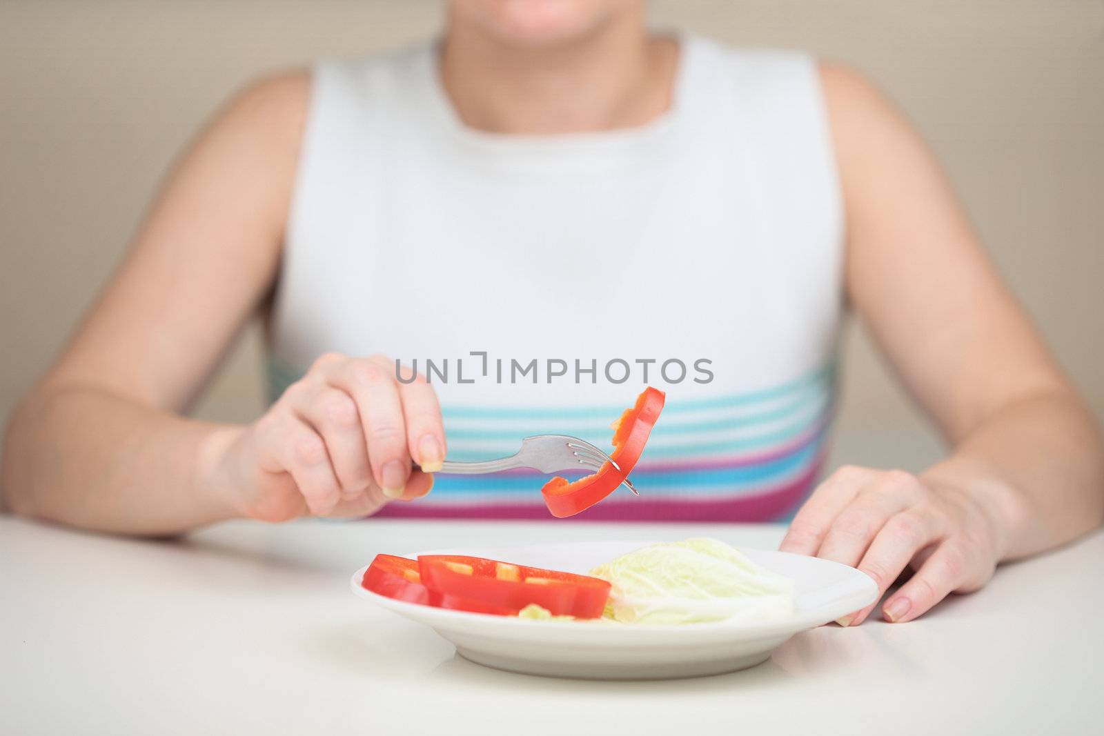 The woman eats vegetables keeping to a strict vegetarian diet