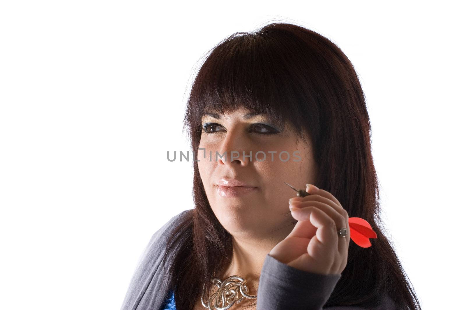 A young woman aiming a dart as she gets ready to throw it at the target. Shallow depth of field.