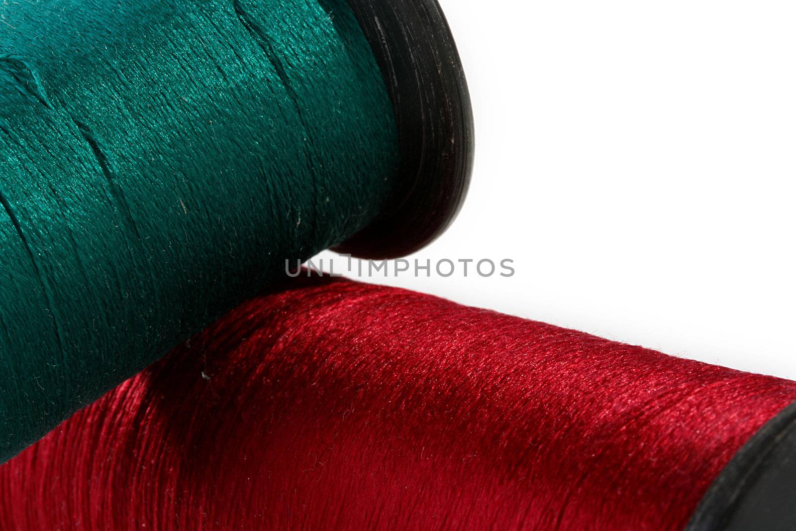 Threads for sewing on coils darkly green and darkly red.