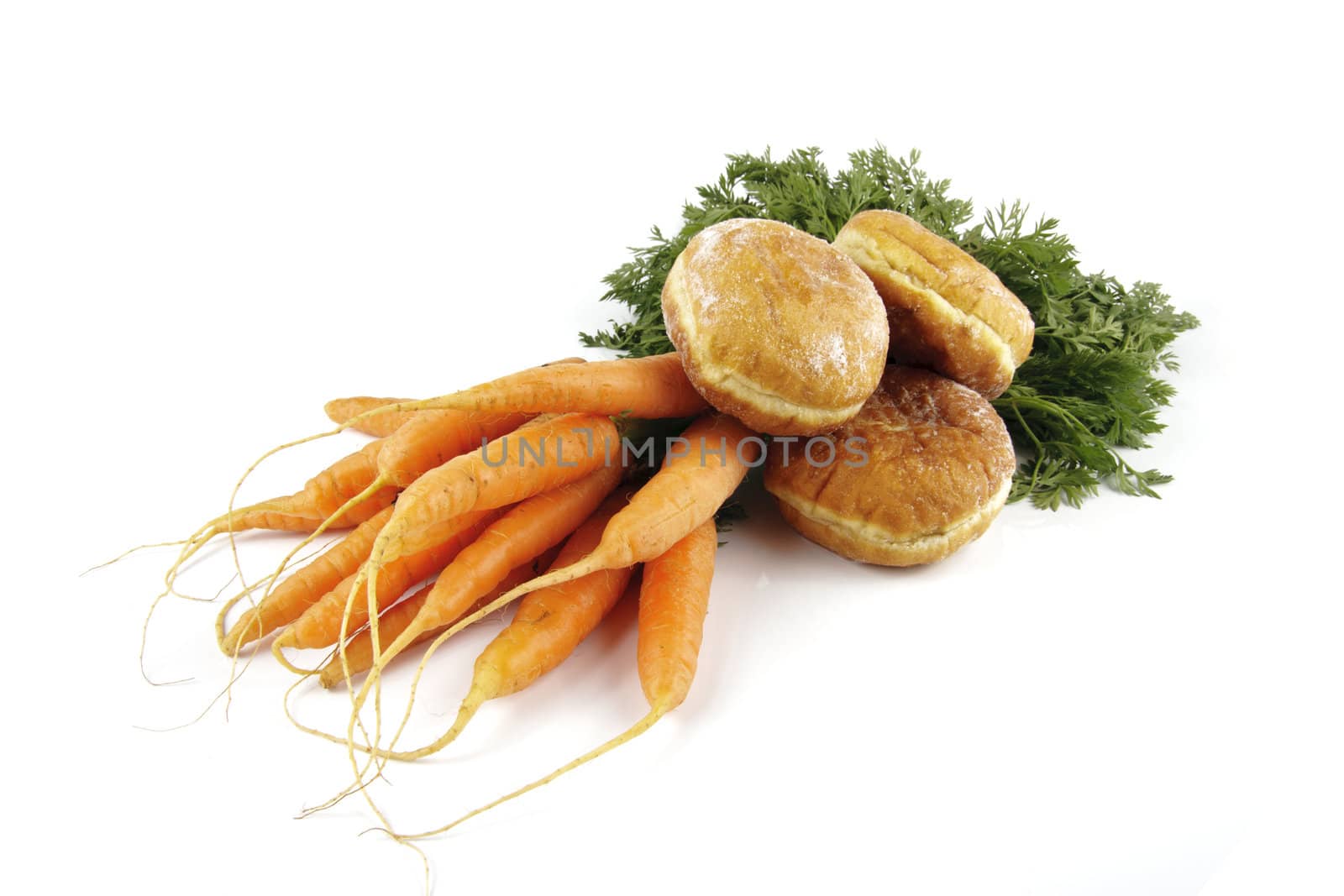 Contradiction between healthy food and junk food using bunch of carrots and doughnut on a reflective white background 