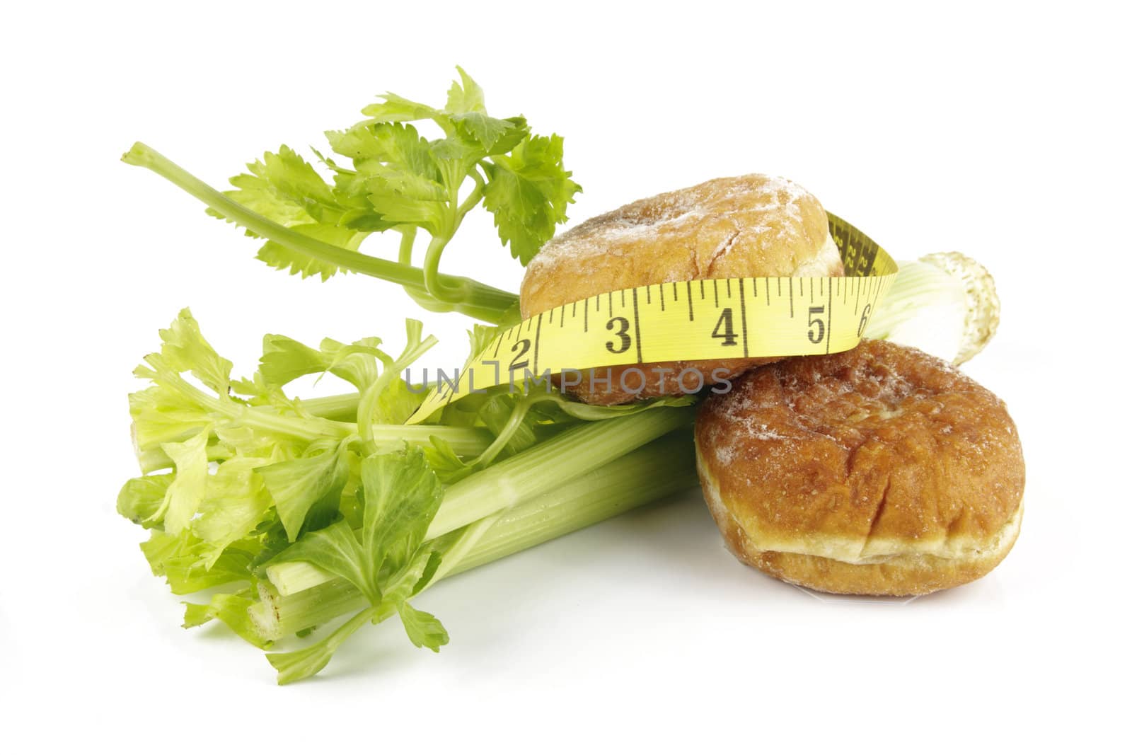 Contradiction between healthy food and junk food using celery and jam doughnut with a yellow tape measure on a reflective white background 
