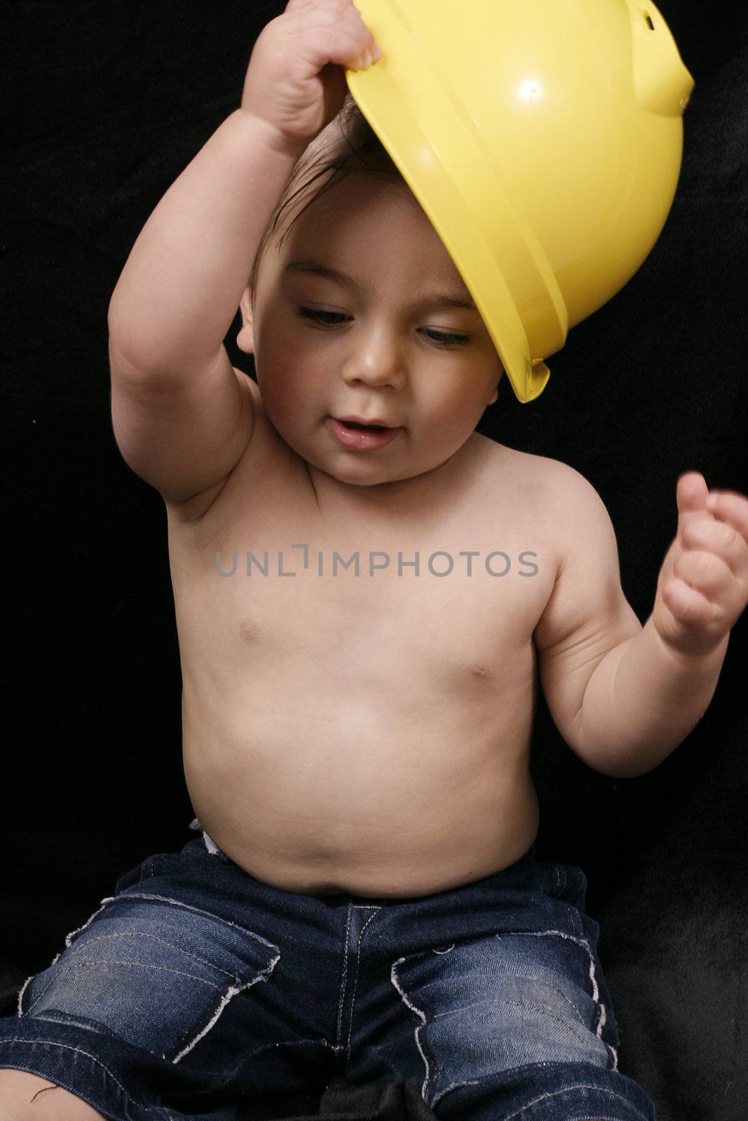 A child plays with a builder's construction hat.