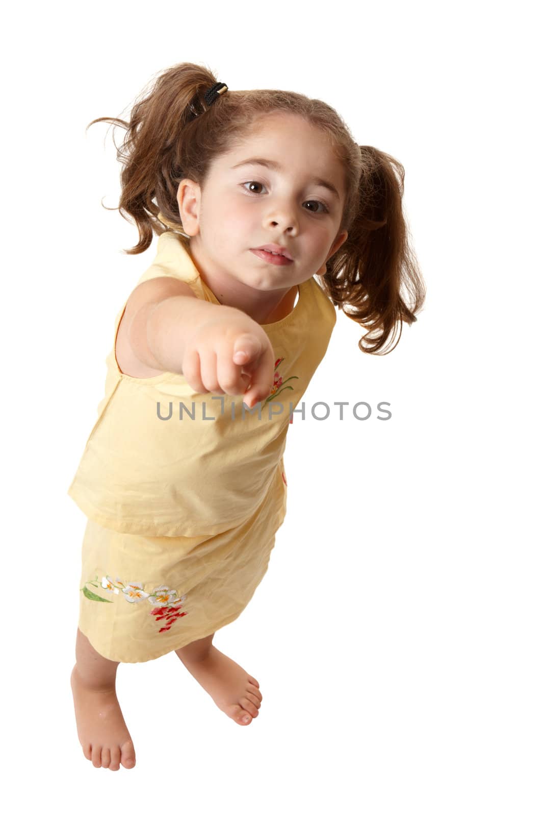 A young girl standing and with one arm outstretched is pointing her finger 