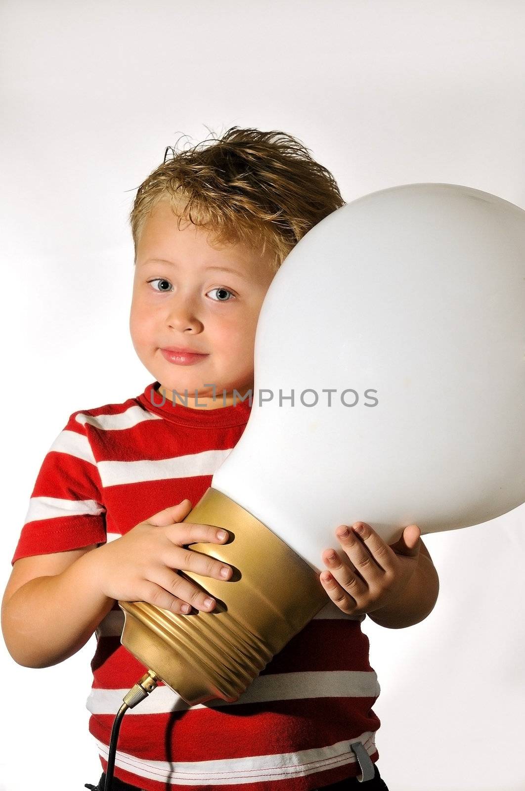 The boy holds the big white bulb in hands 
