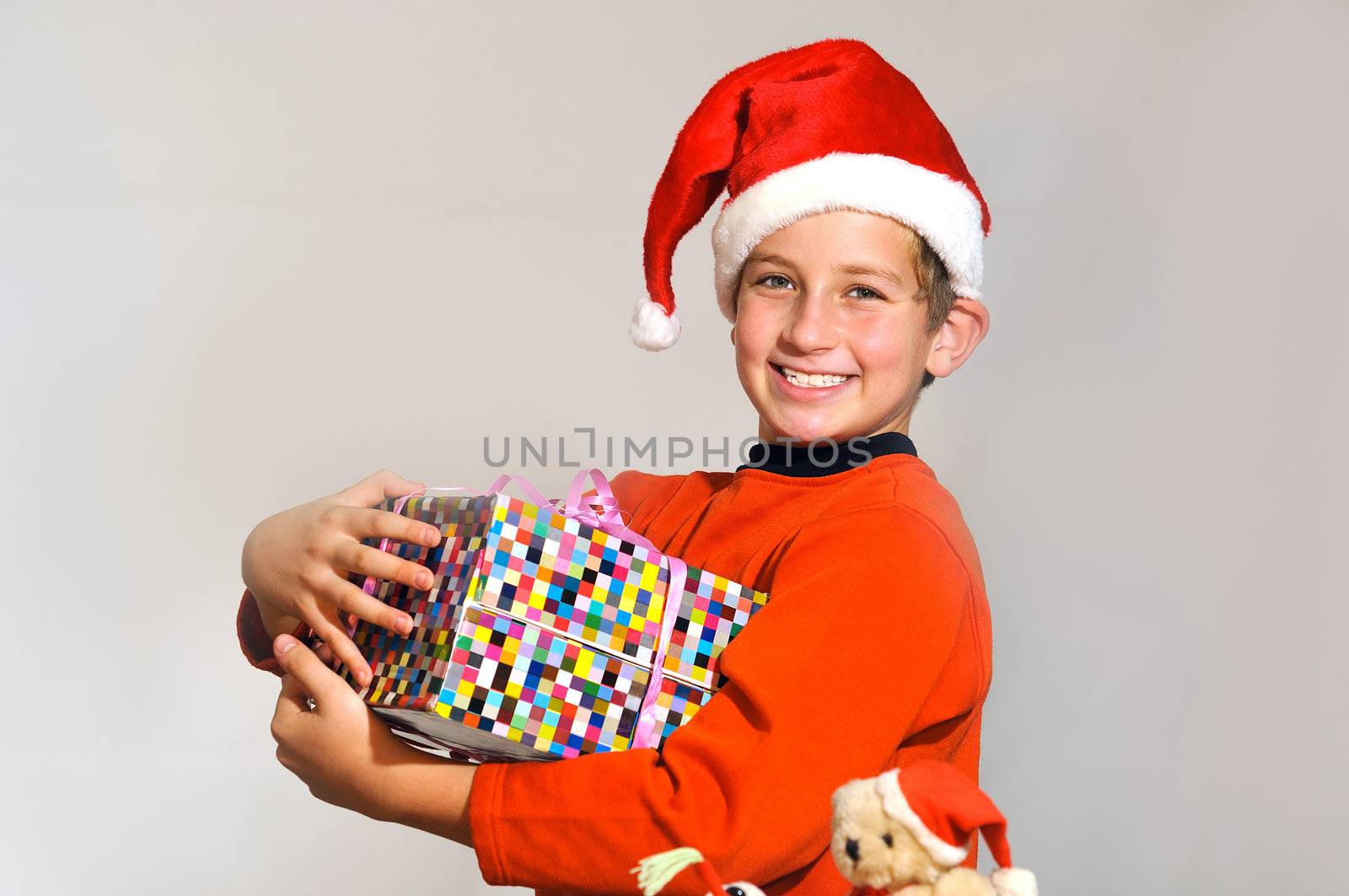 
a smiling boy in a red cap, holding a box with a gift 