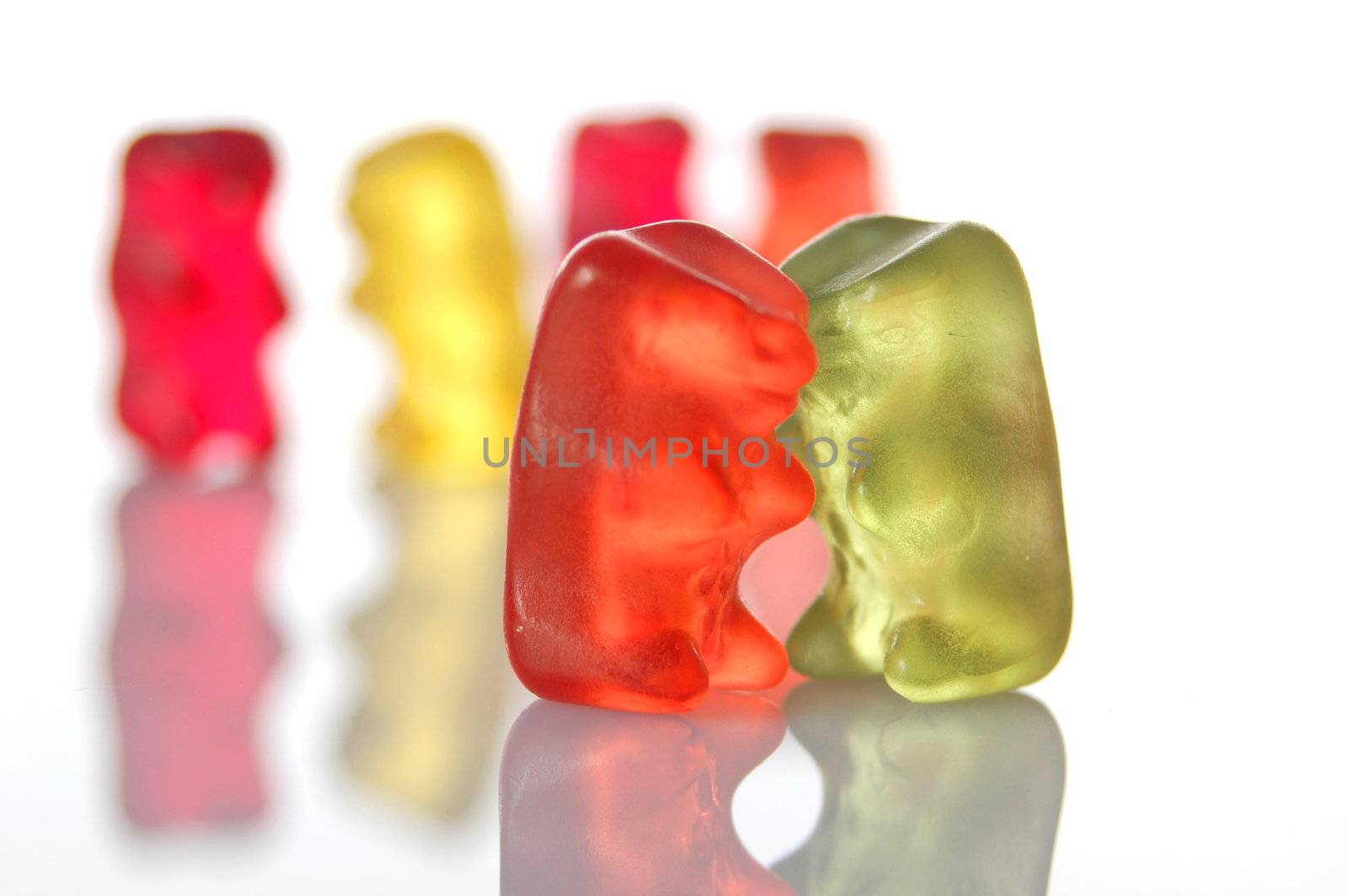 sweet gummy bears dancing on a party on white background