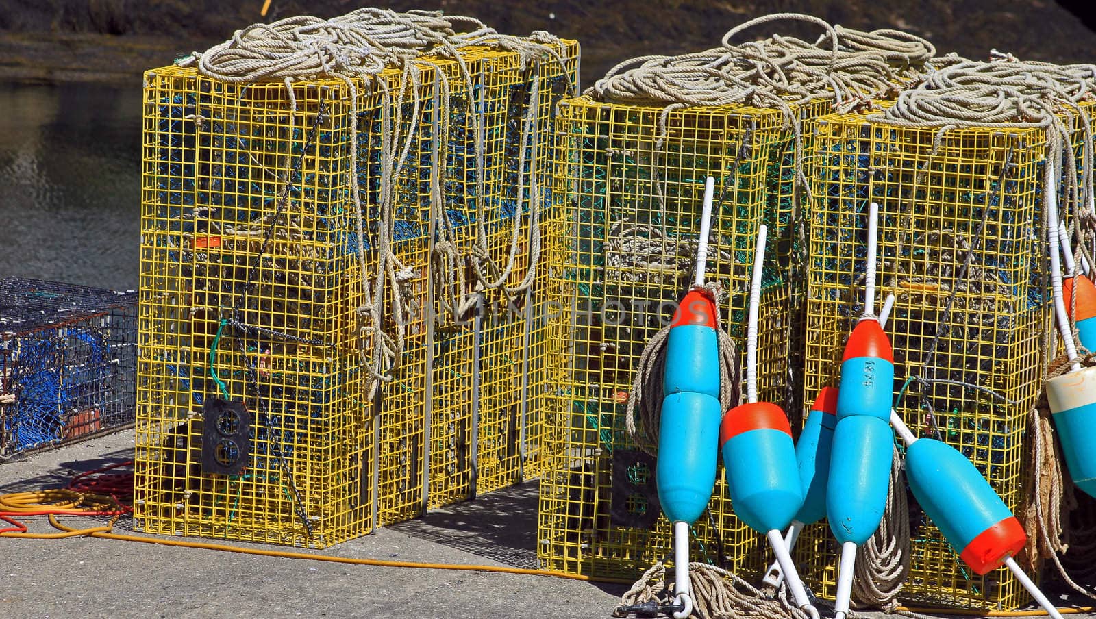 Lobster buoys leaning on cages on fishing wharf