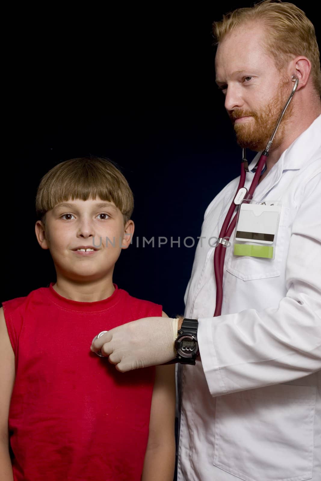 Doctor using a stethoscope with young child patient.