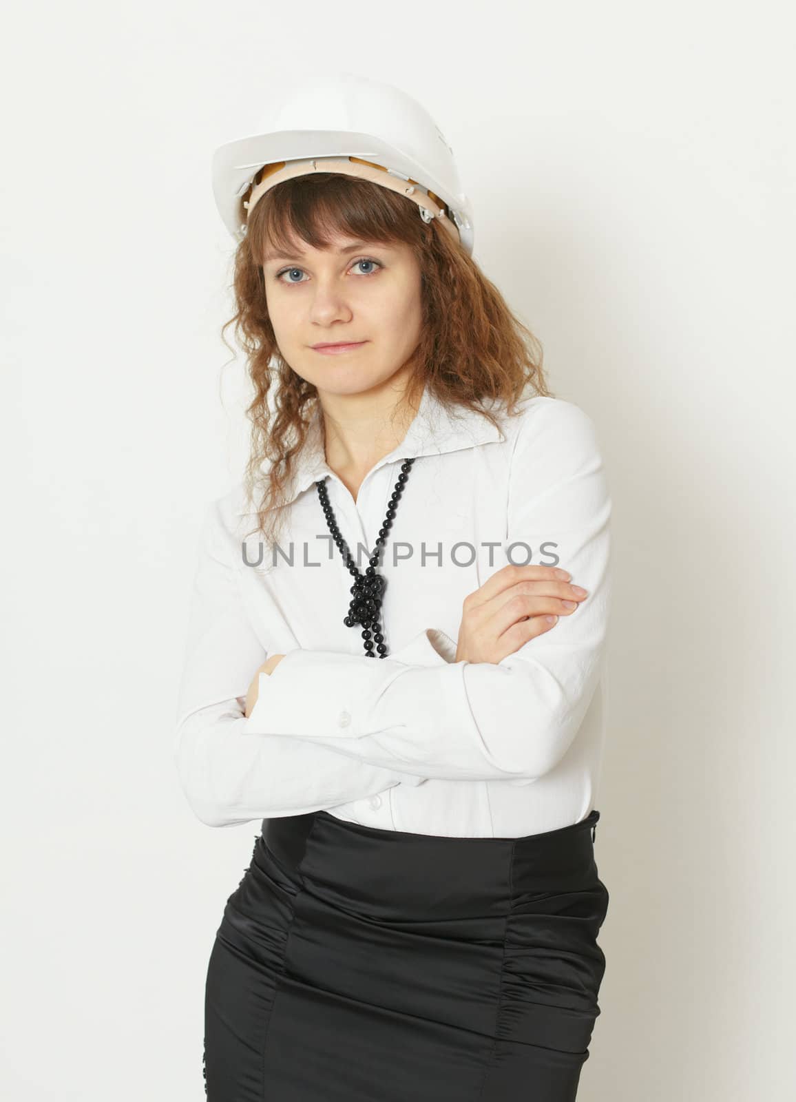 The young beautiful woman in a building protective helmet