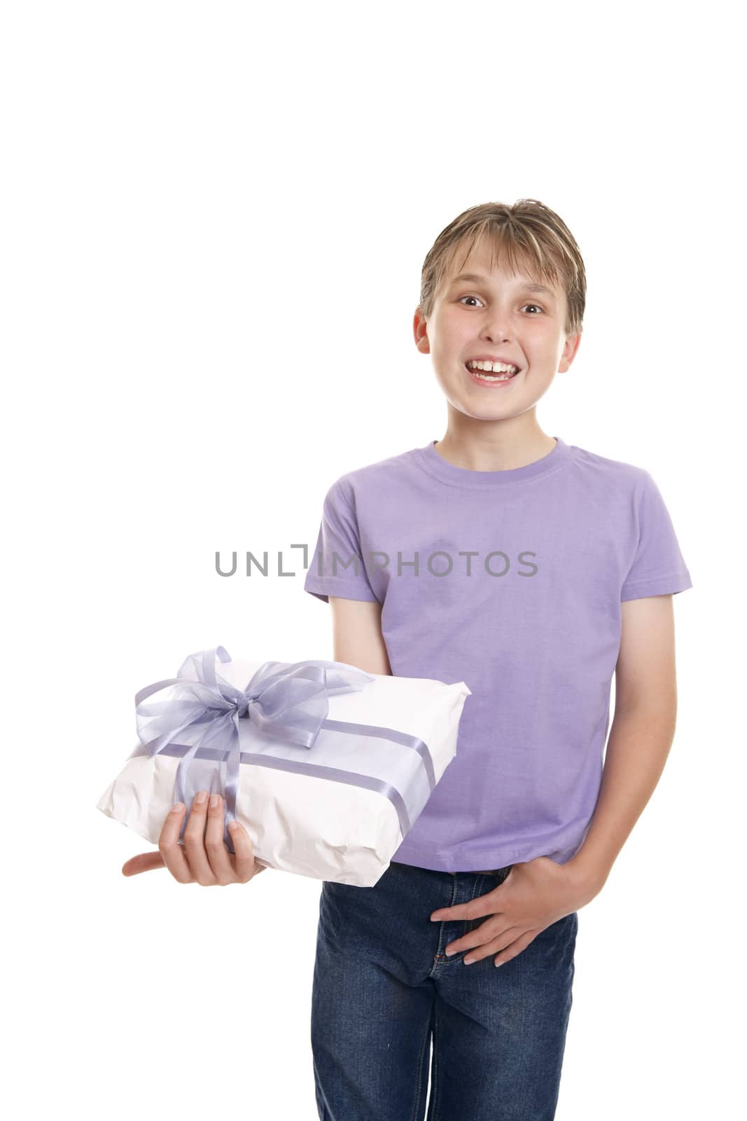 Excited  boy in plain t-shirt and jeans holding a wrapped present ready for birthday or other special occasion.