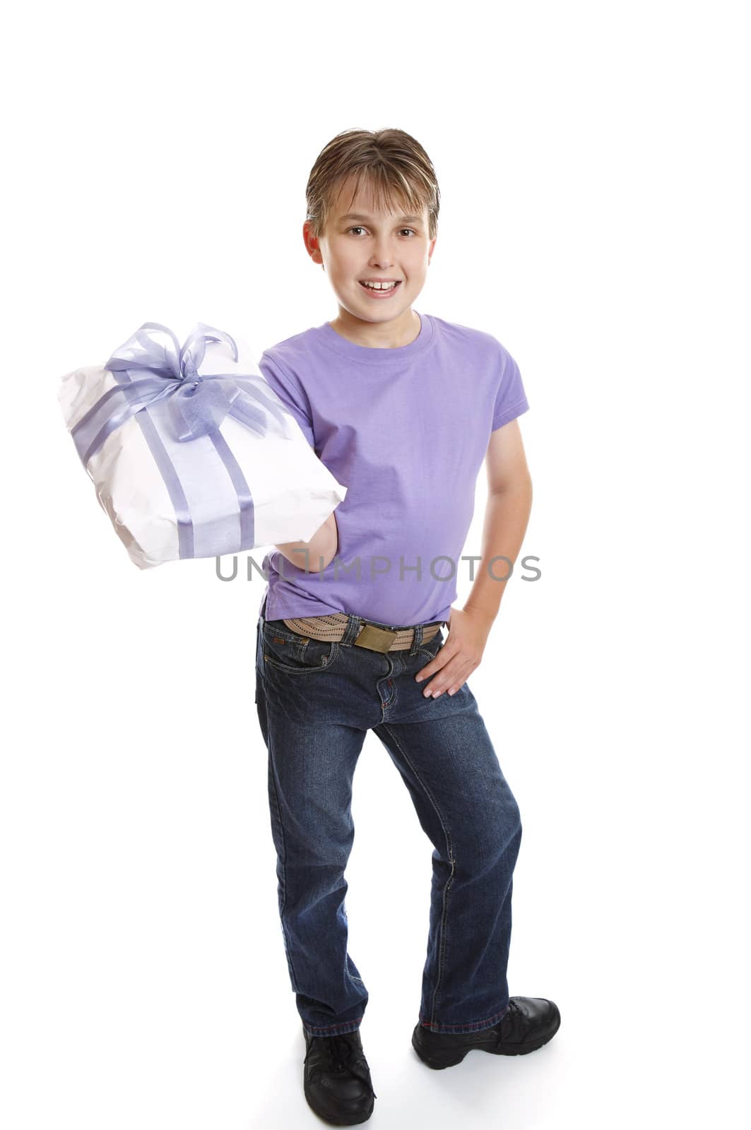 A young boy dressed in jeans and t-shirt holds a present tied up with a big ribbon ow.