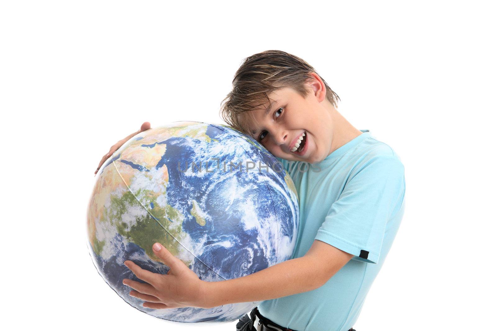 A young boy with his hands hugging the world earth ball.  He is leaning his head into the earth affectionately and smiling.  Concept environmental protection, world care, travel eco-tourism, etc