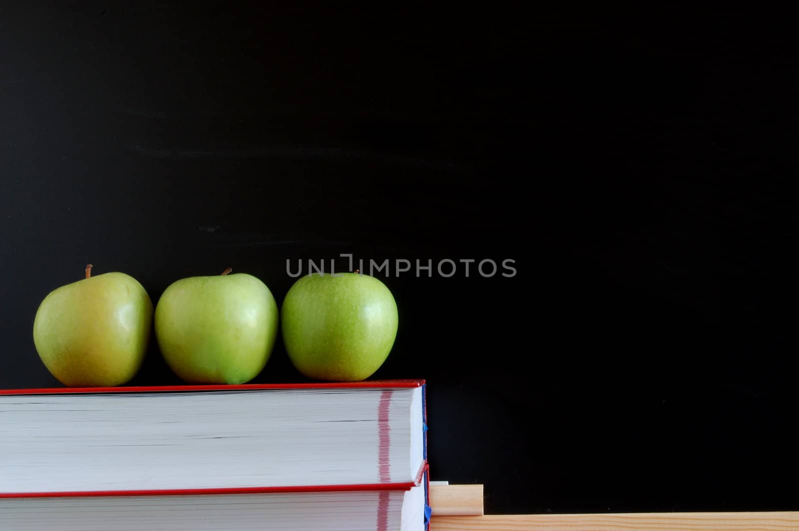 blank blackboard with apple and books and text space