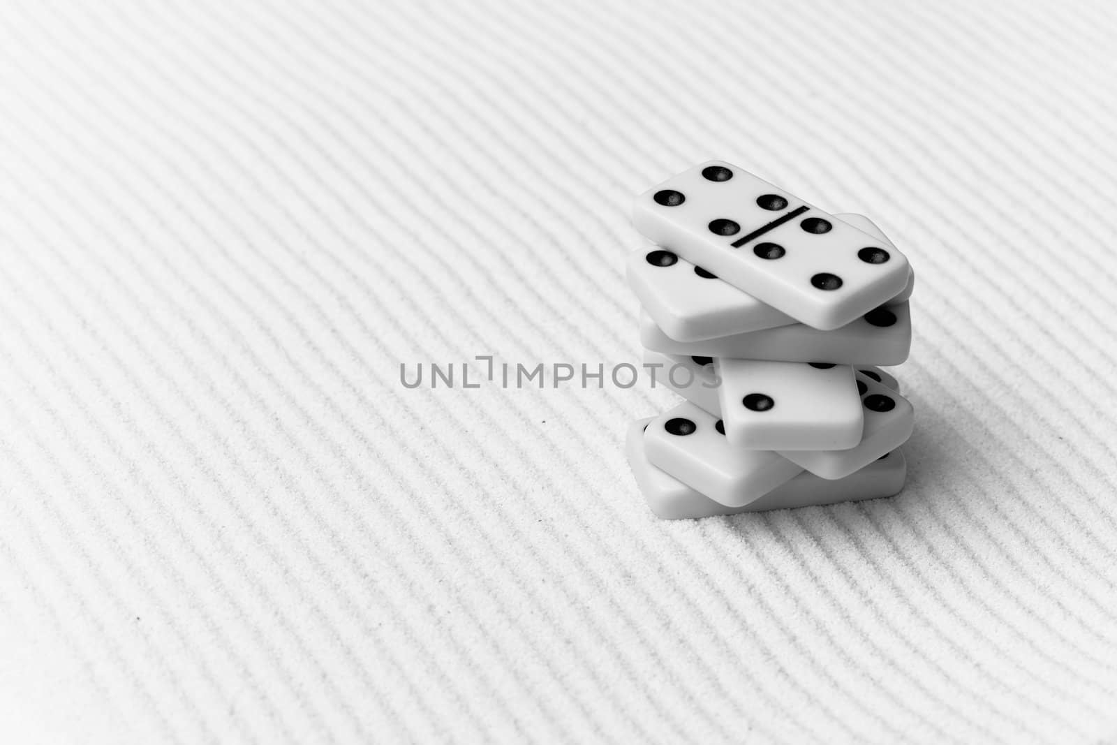 The dominoes are piled against grey sand