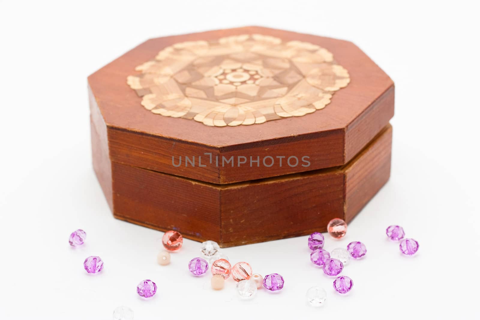 Embellishments and hexagonal box opened slightly isolated on white