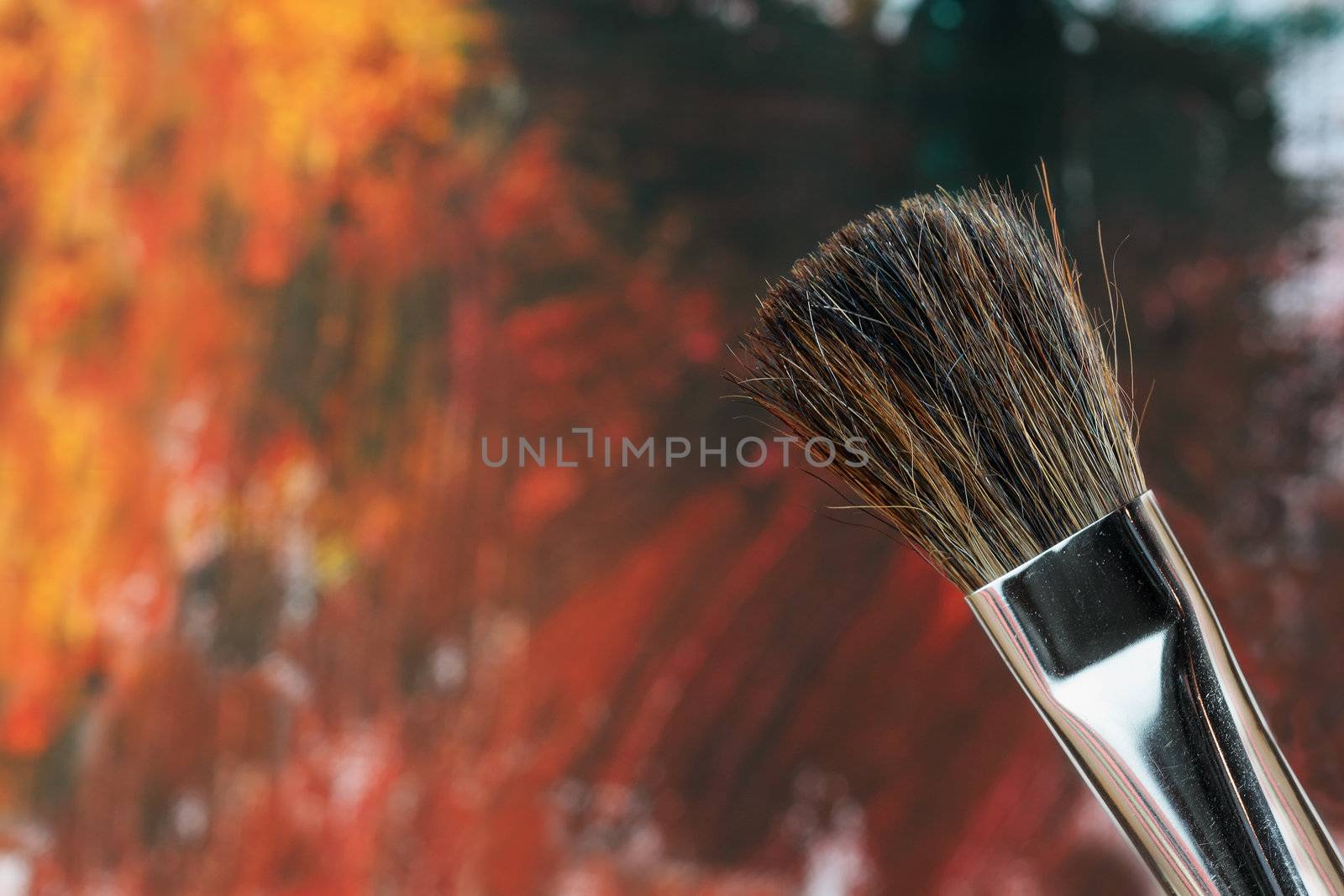 Paintbrush against an abstract grunge painting.