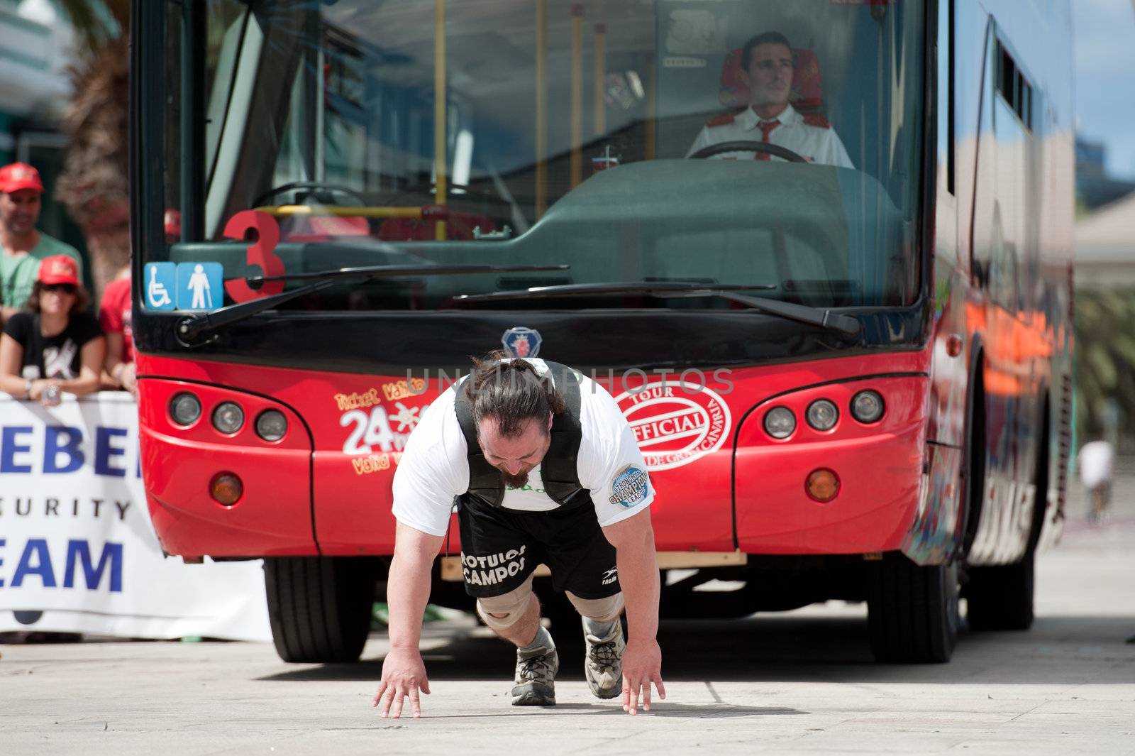 CANARY ISLANDS – SEPTEMBER 03: Julio Jimenez Zancajo from Spain pulling a double-decker bus behind himself during Strongman Champions League in Las Palmas September 03, 2011 in Canary Islands, Spain
