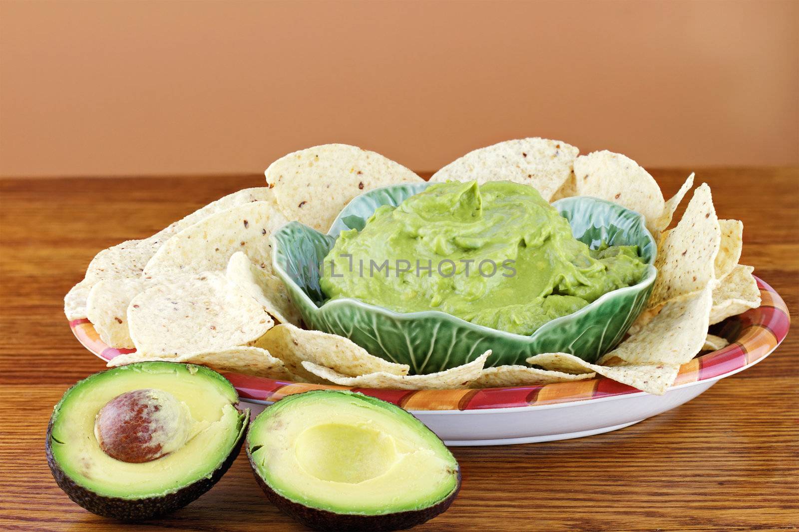 Fresh  avocado with guacamole and tortilla chips in the background. Extreme shallow DOF.
