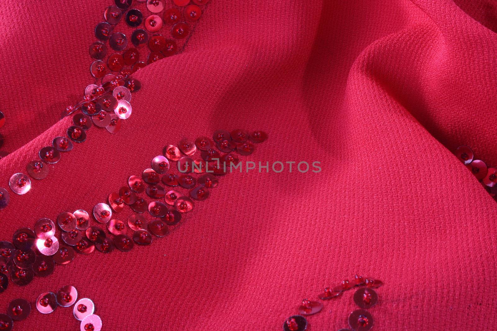 Darkly red fabric with an embroidery from seed bead for use as a background.