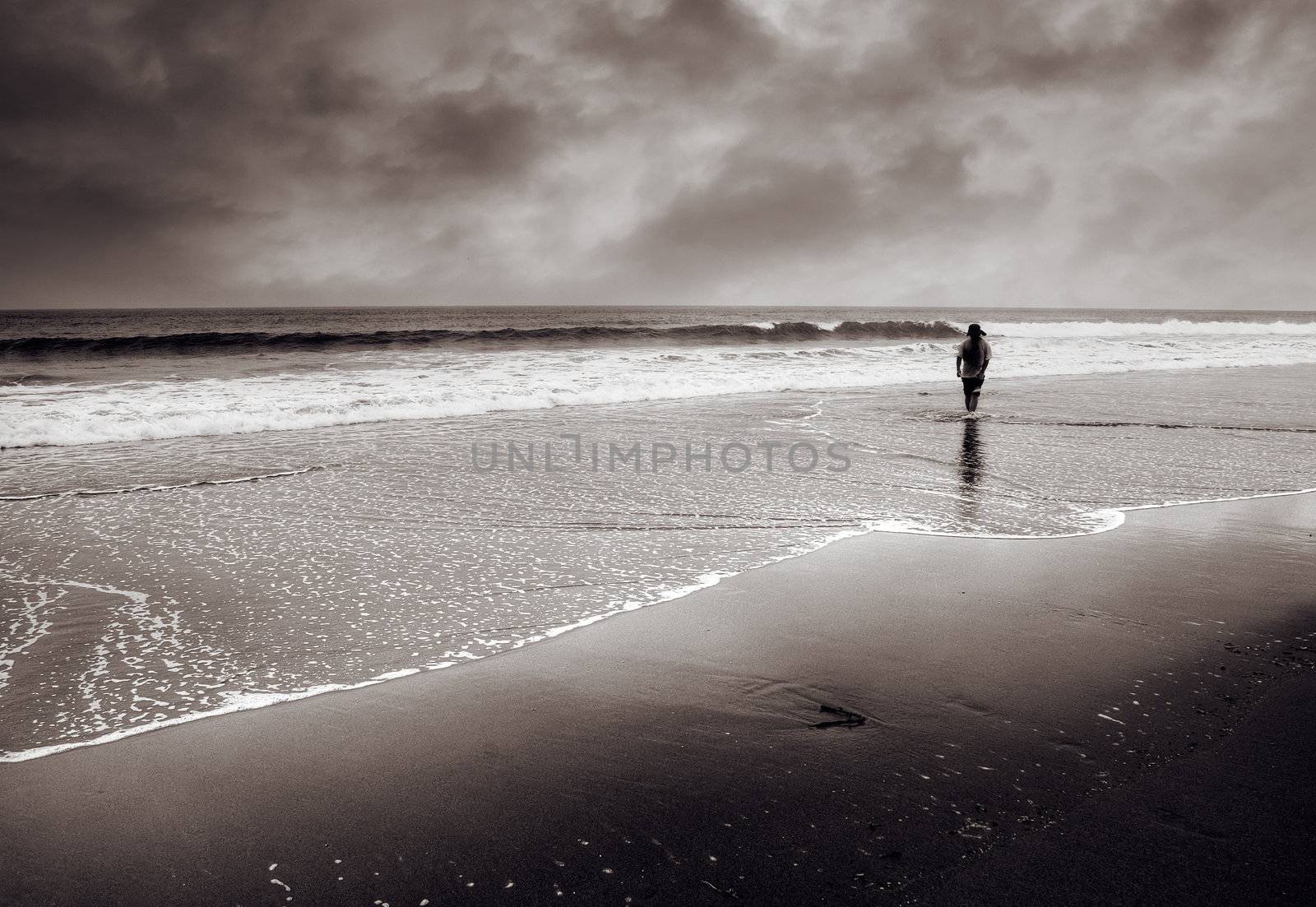 Dramatic landscape of single man walk at beach.