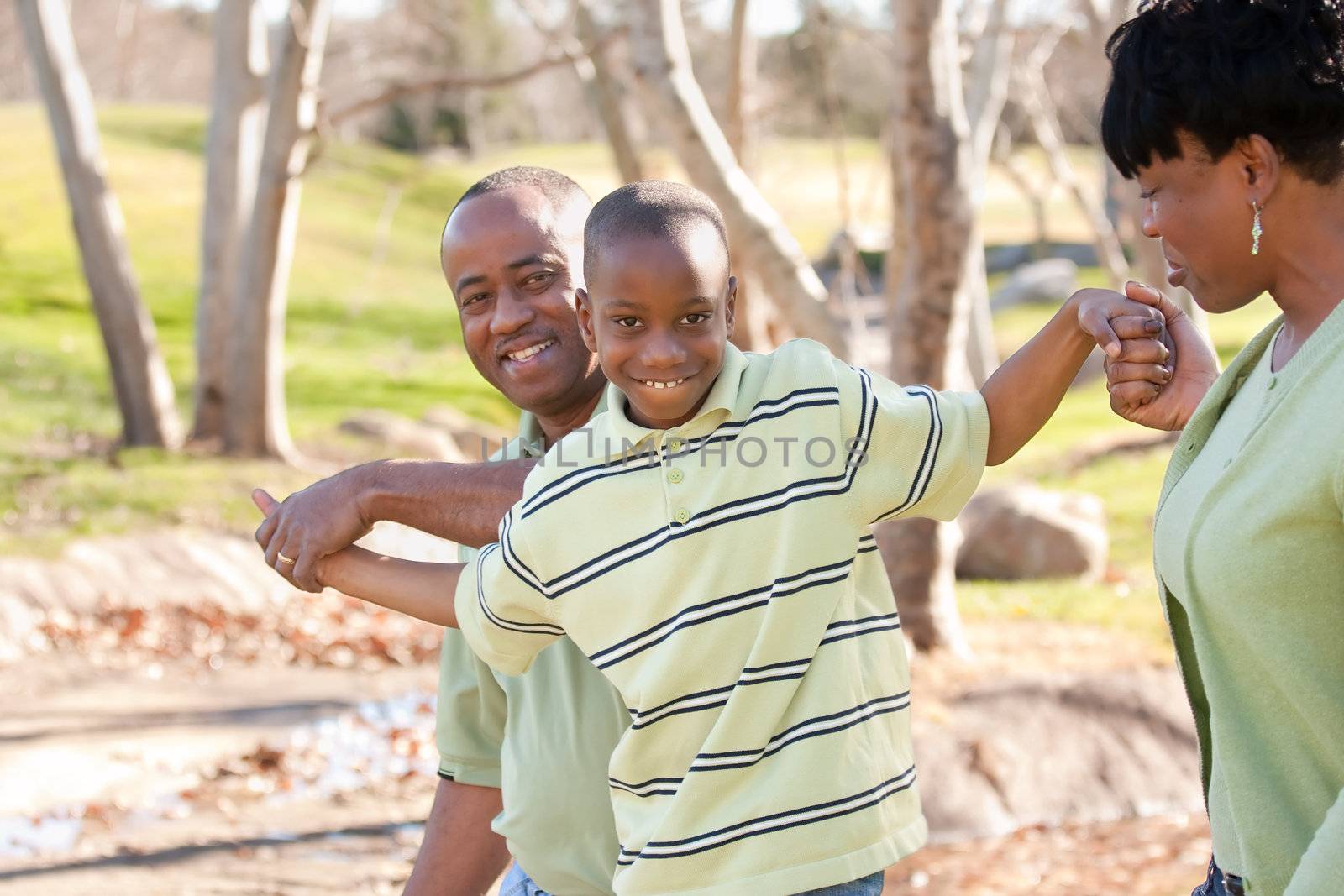 Happy African American Man, Woman and Child Having Fun in the Park.