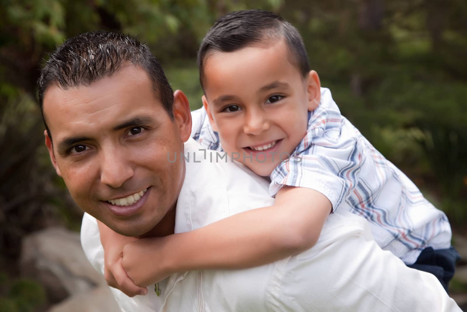 Hispanic Father and Son Having Fun in the Park by Feverpitched