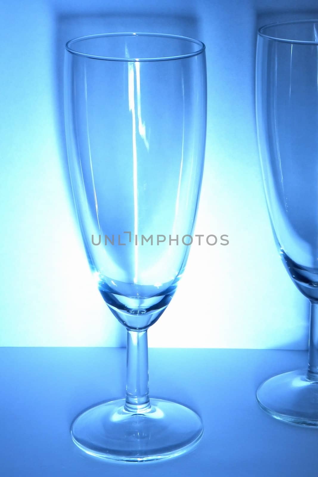 Wine glasses on the white and blue background with delicate shadow.