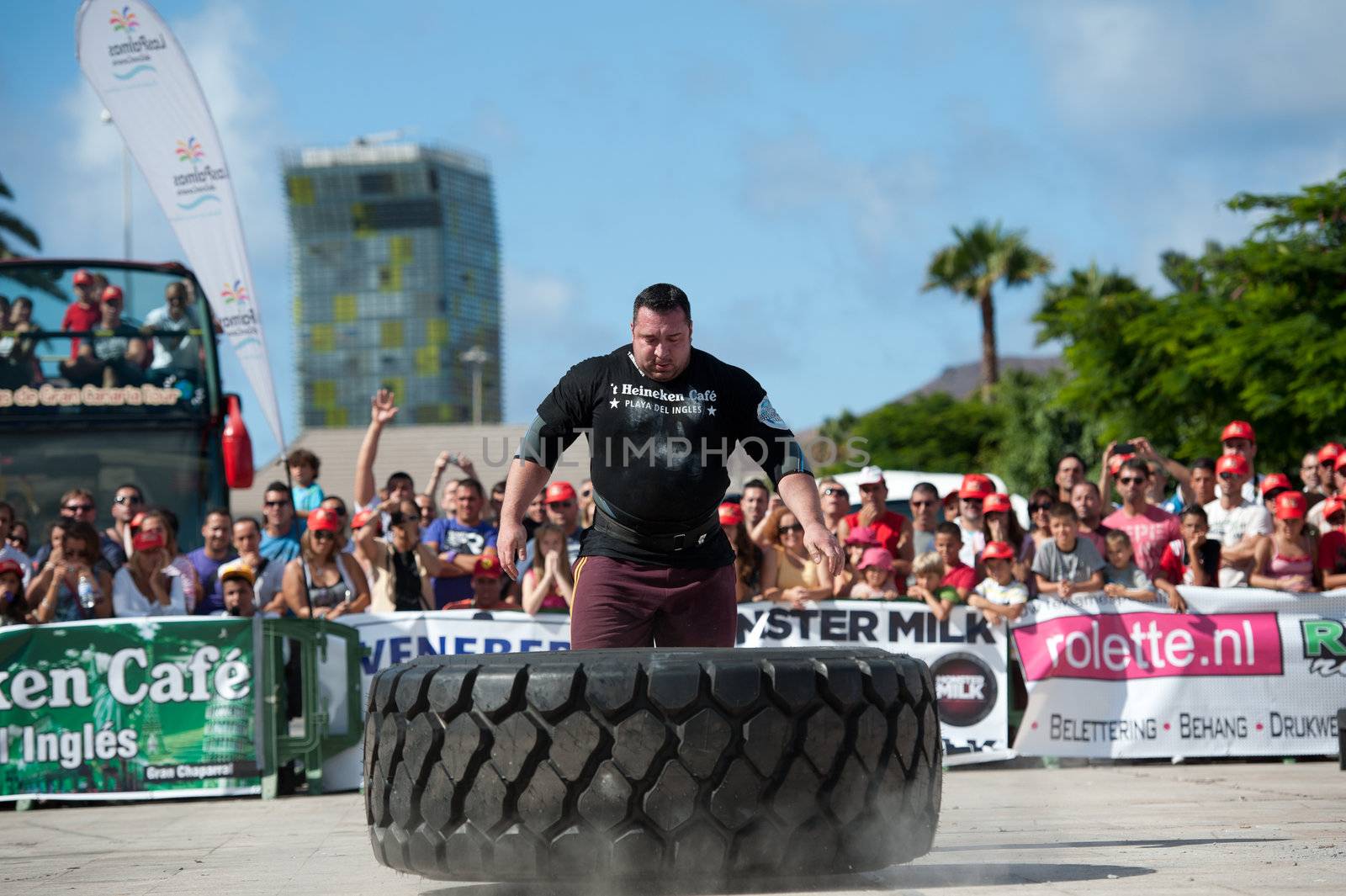 CANARY ISLANDS - SEPTEMBER 03: Alex Curletto from Italy lifting and rolling a wheel (weights 400kg) 8 times during Strongman Champions League in Las Palmas September 03, 2011 in Canary Islands, Spain