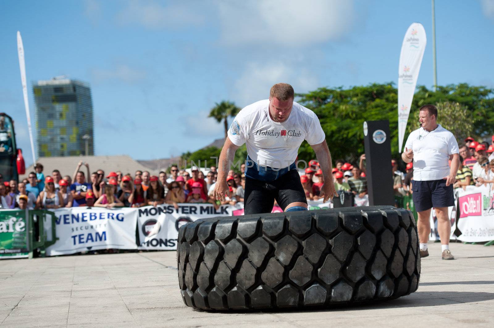 CANARY ISLANDS - SEPTEMBER 03: Lauri Nami (m) from Estonia lifting and rolling a wheel (weights 400kg) 8 times during Strongman Champions League in Las Palmas September 03, 2011 in Canary Islands, Spain