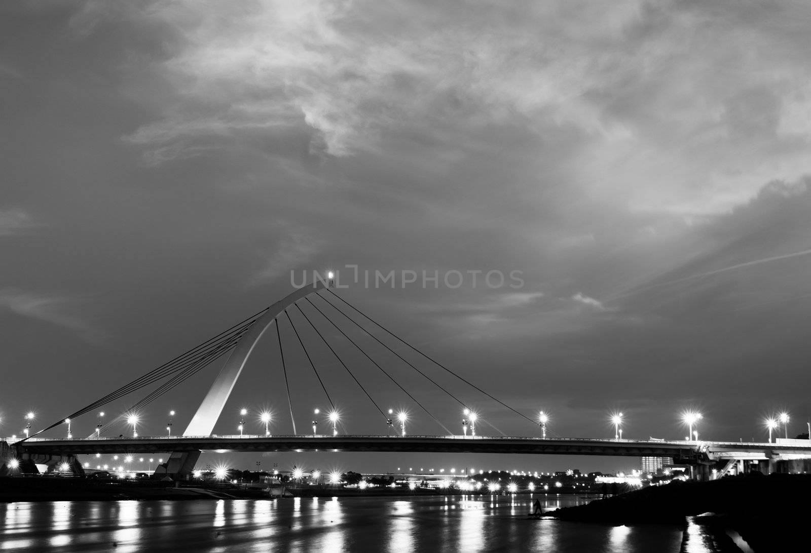 Dramatic cityscape of beautiful bridge over the river with lights reflection.