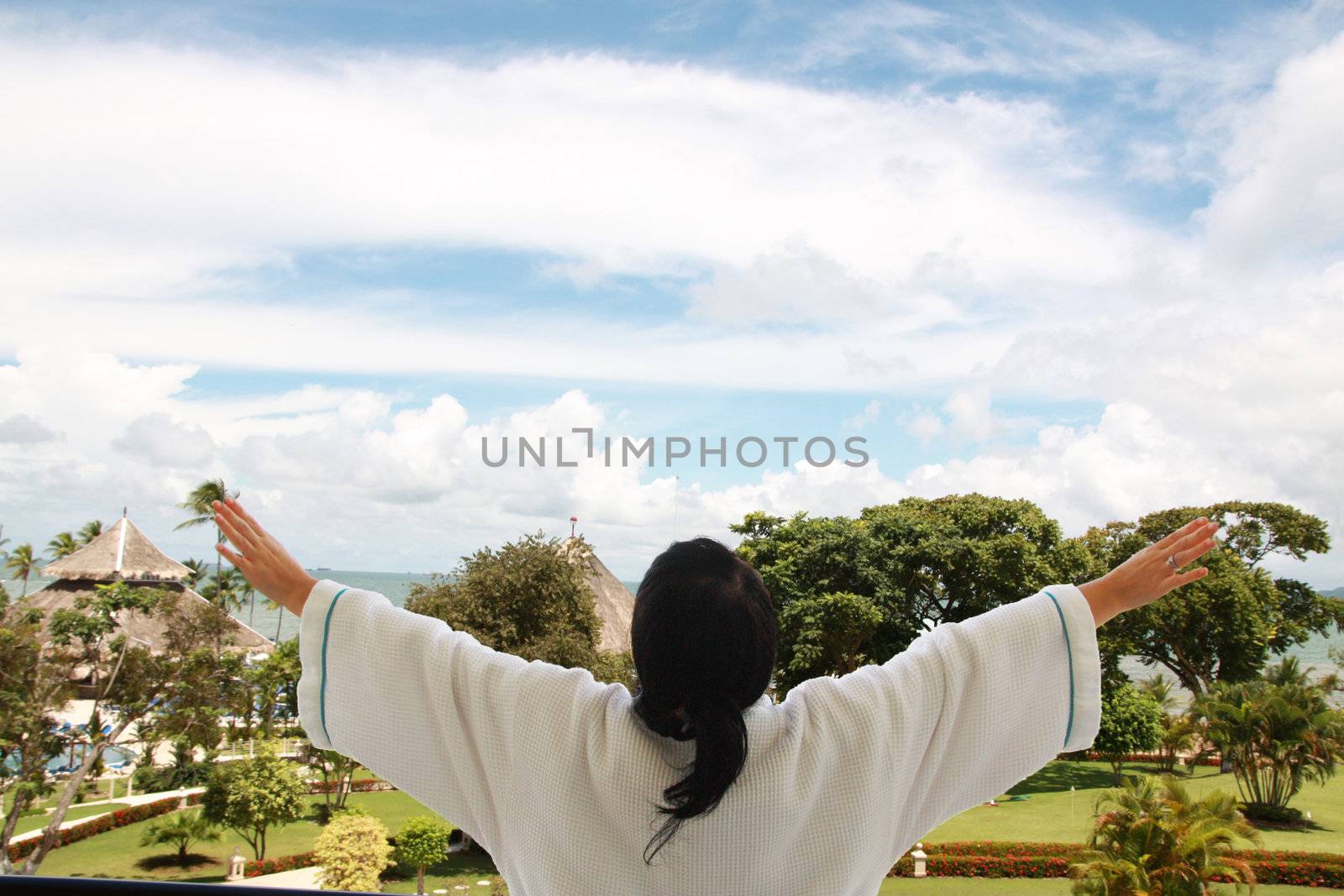 women on the balcony taking a fresh air in background sea and island