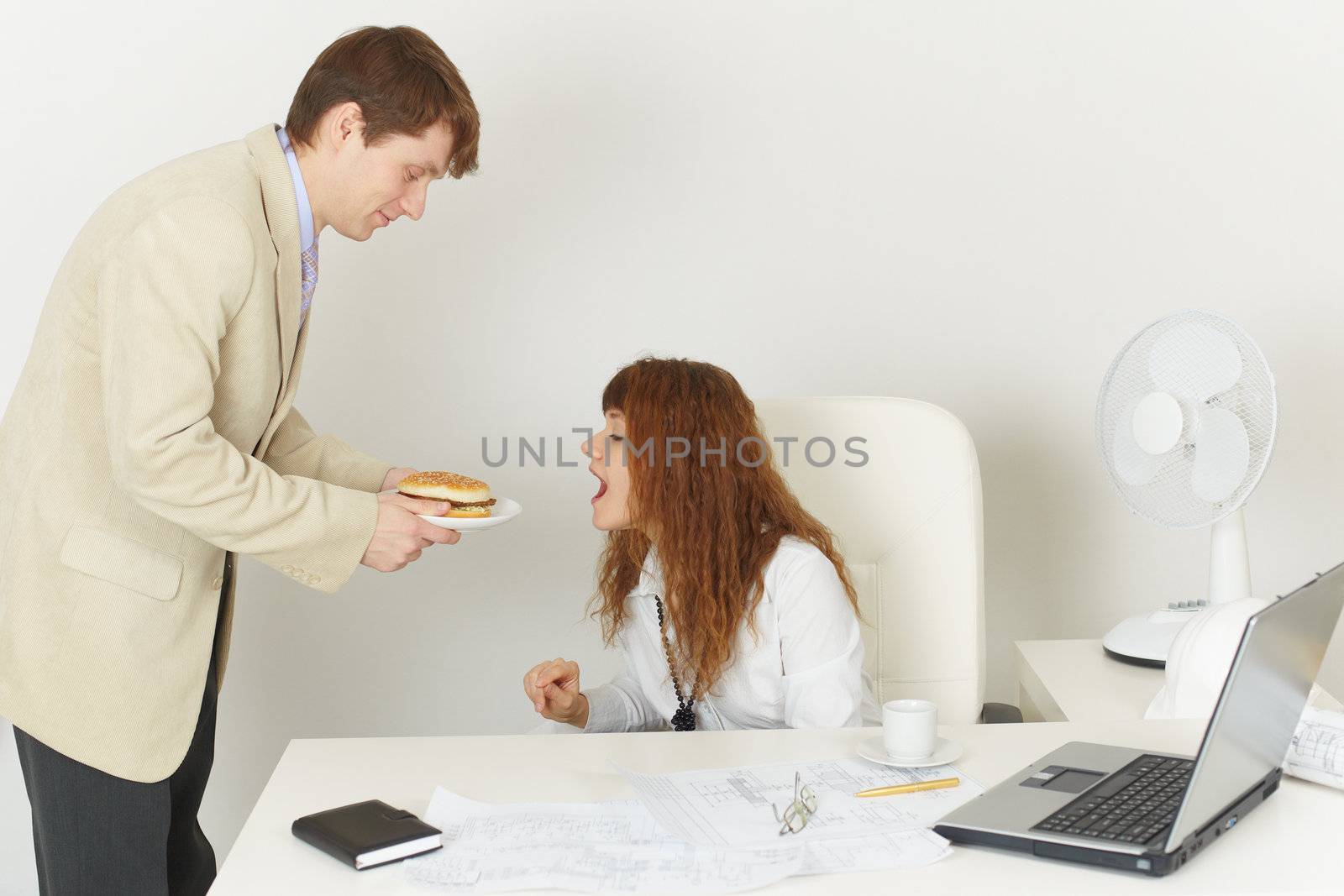 The young woman comically reaches for meal at office during the lunchtime