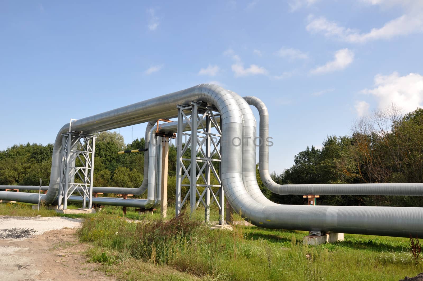 Industrial pipelines on pipe-bridge against blue sky