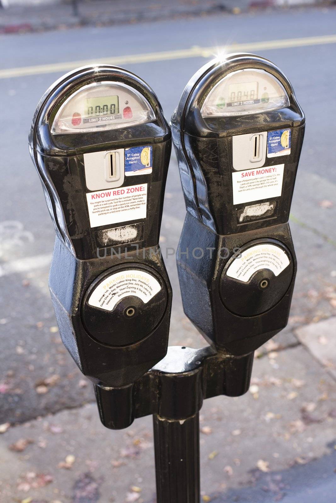 Closeup of Two Parking Meters on Sidewalk