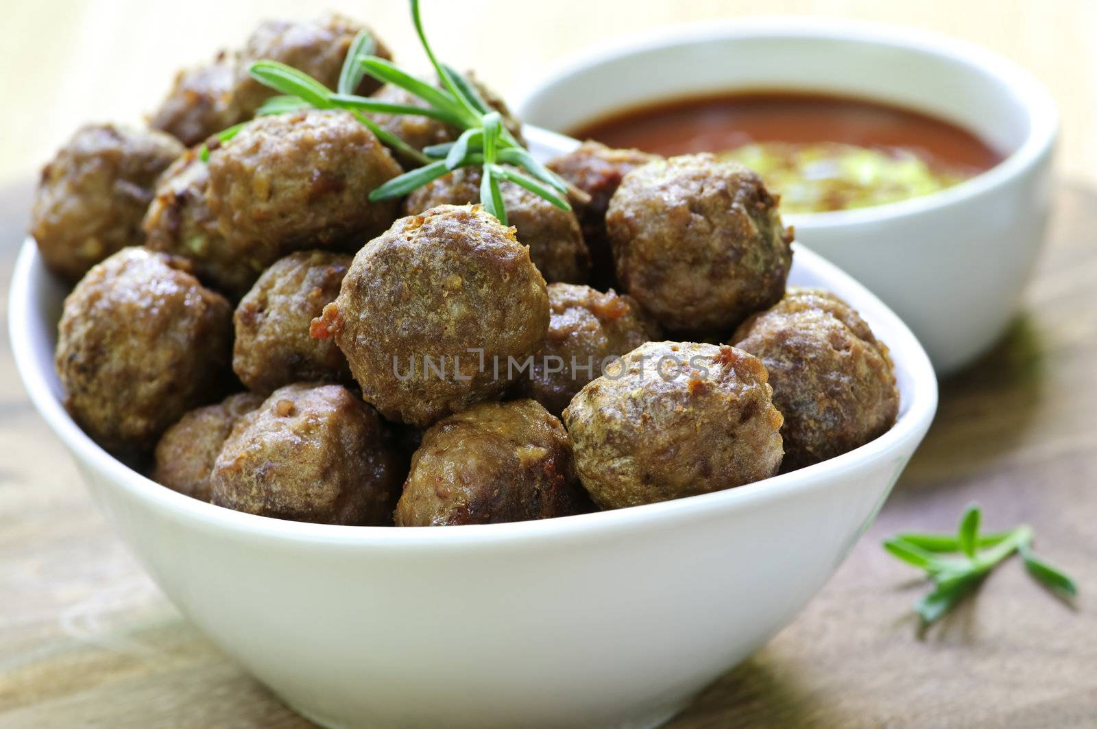 Fresh hot meatball appetizers served in white bowl with dipping sauce