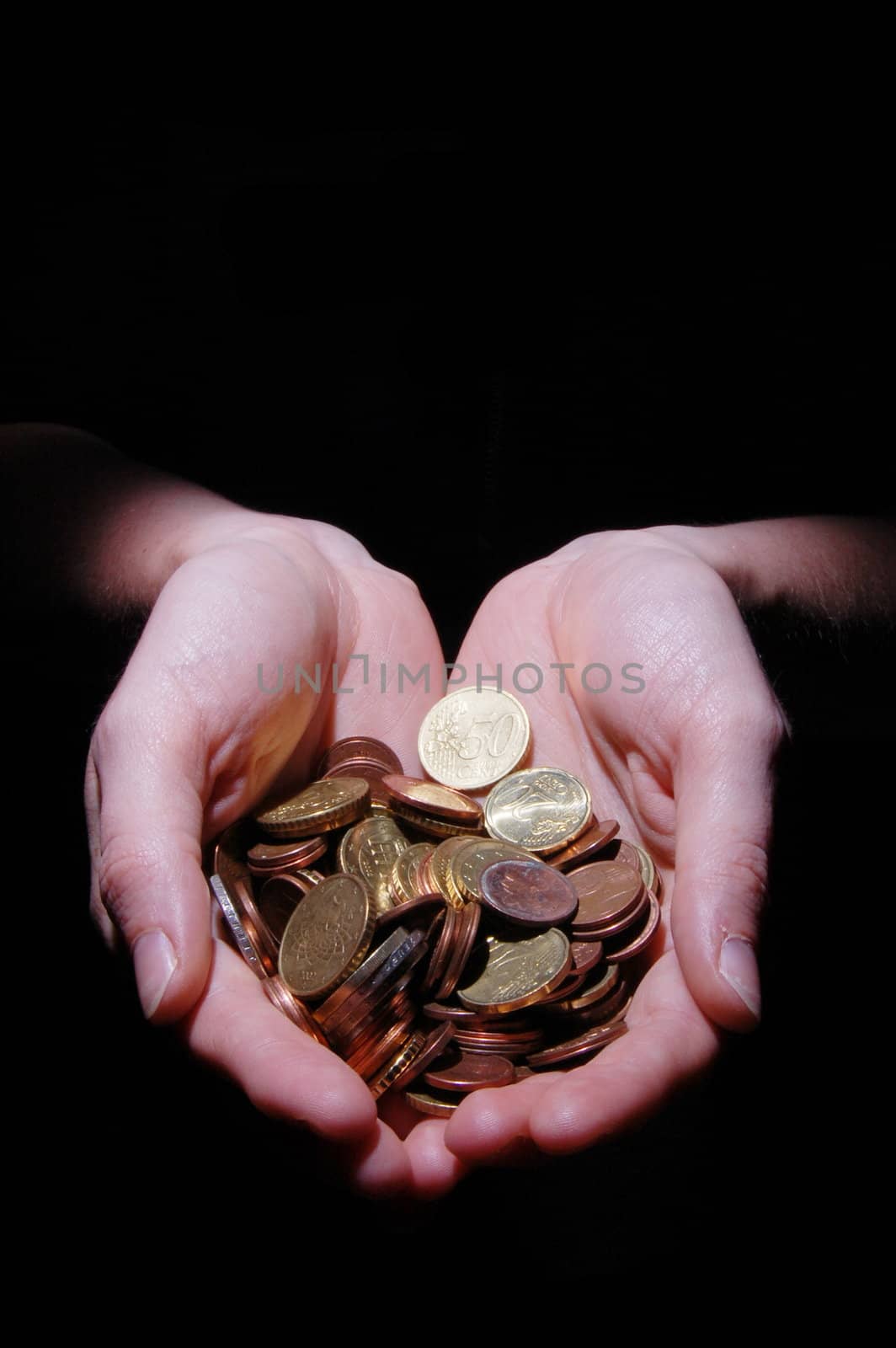 hands with money coins on a black background