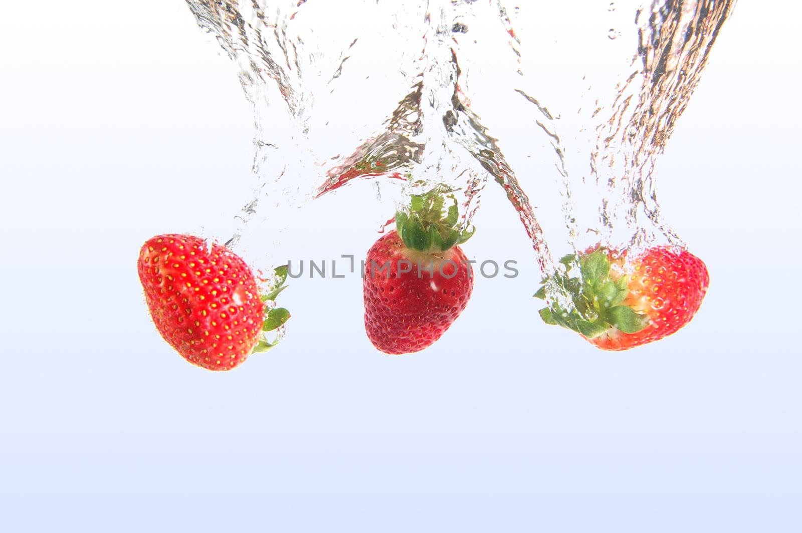 healthy strawberry fruits splashing in cool water