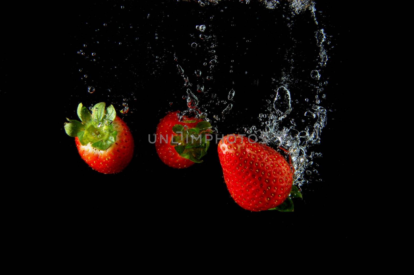 strawberry splashing in water in white background