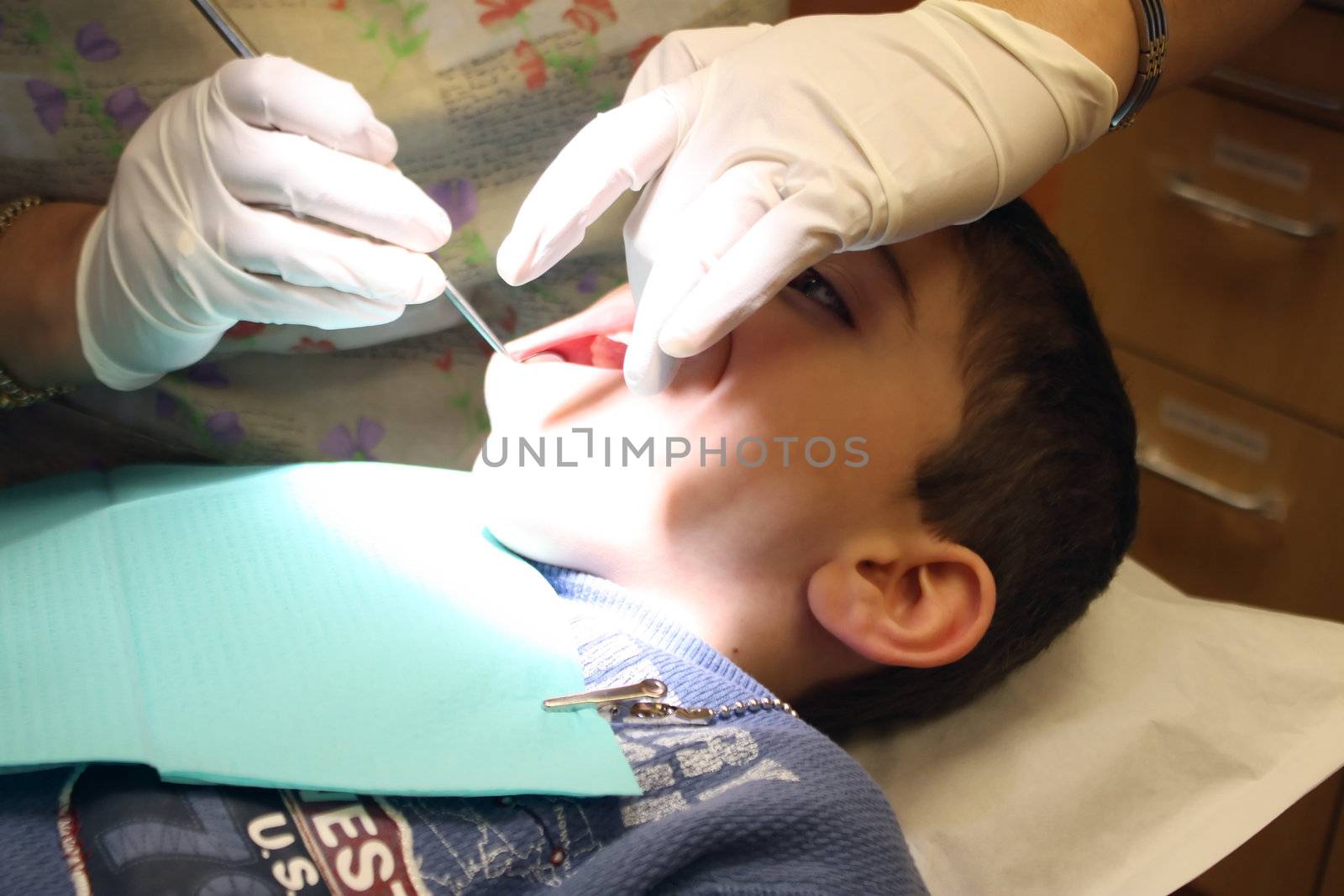 a boy gets a routine check up at the dentist