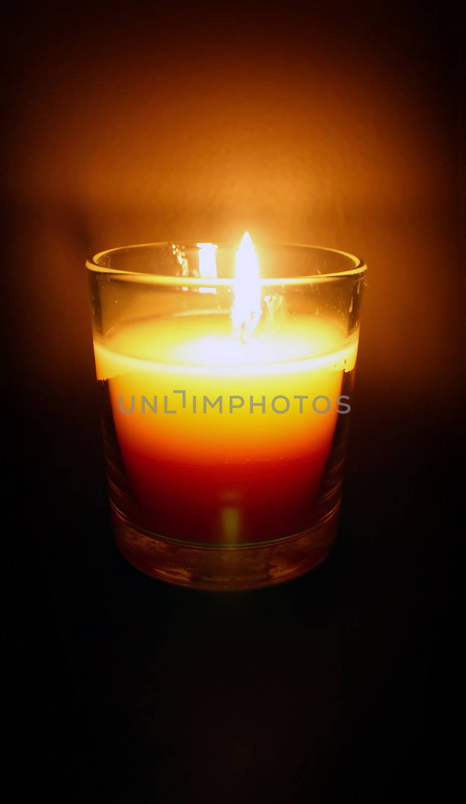 a candle blazes in a dark room
