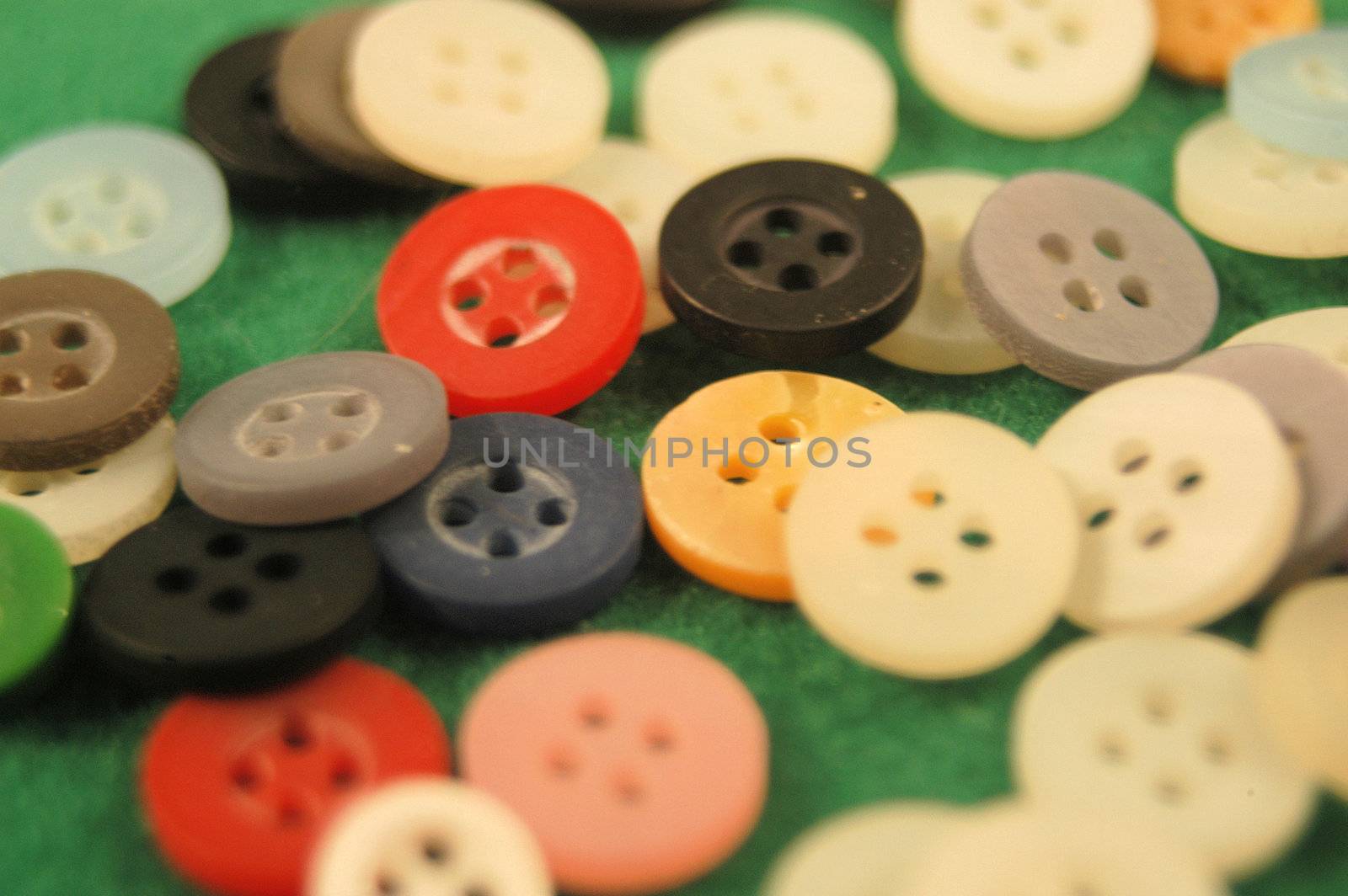 A large pile of buttons on a field green