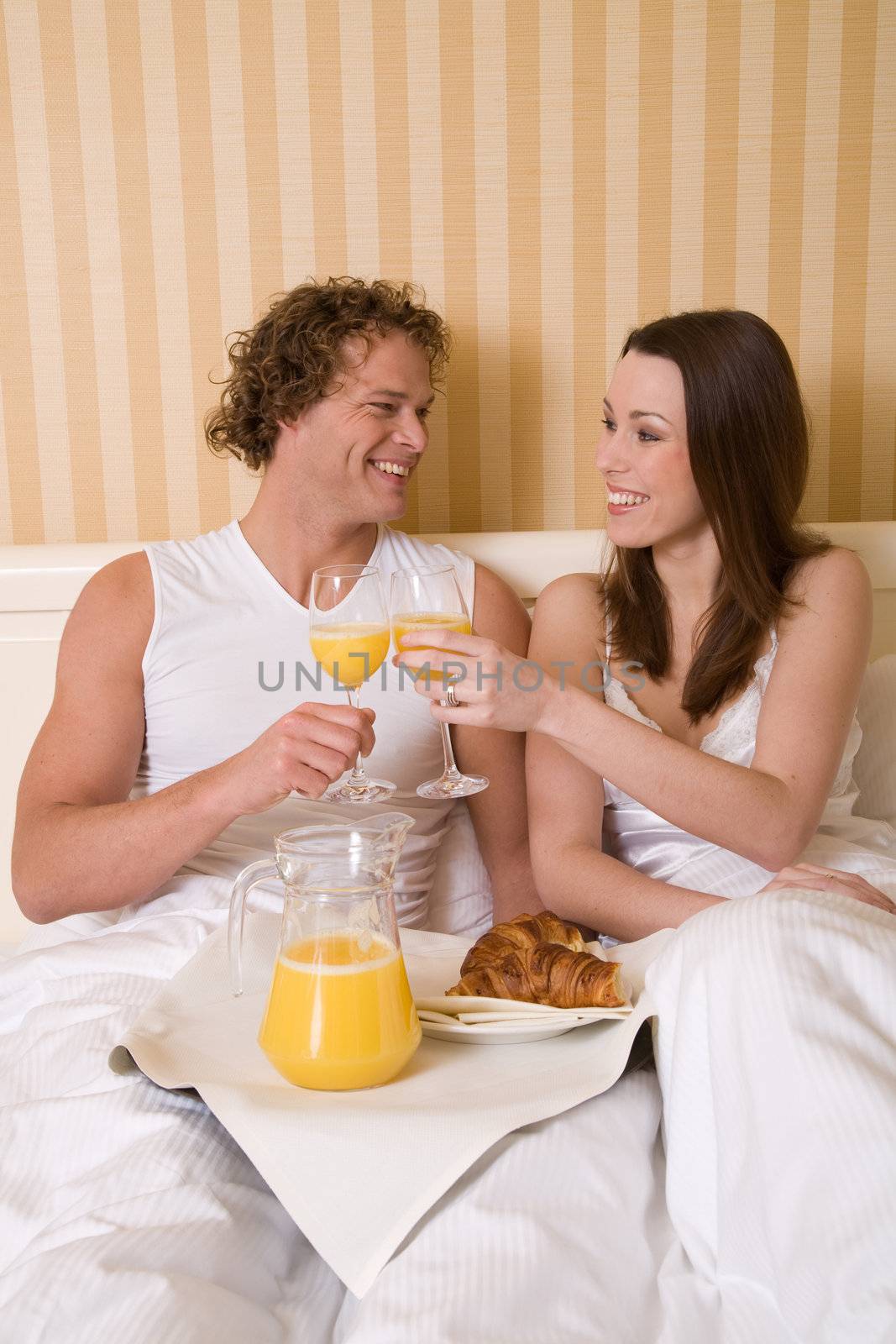 Happy couple having a fresh breakfast in bed