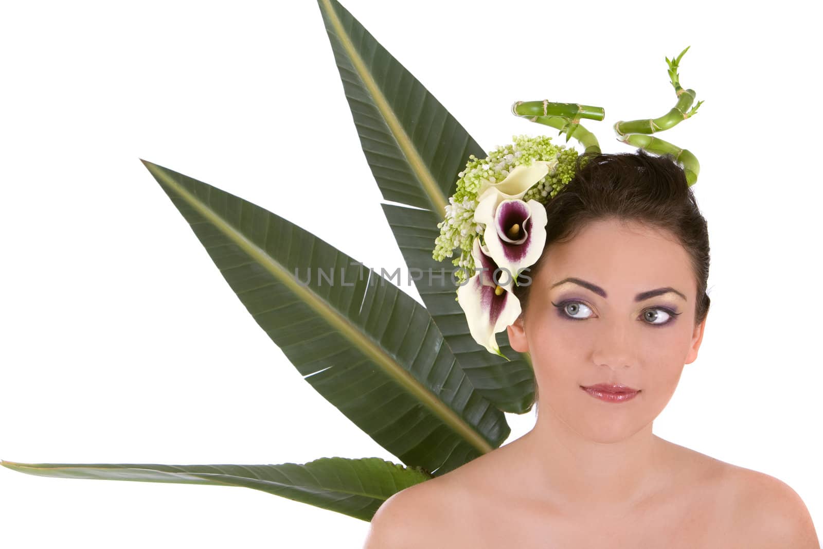 Beautiful woman with flowers in her hair and big leaves in the background