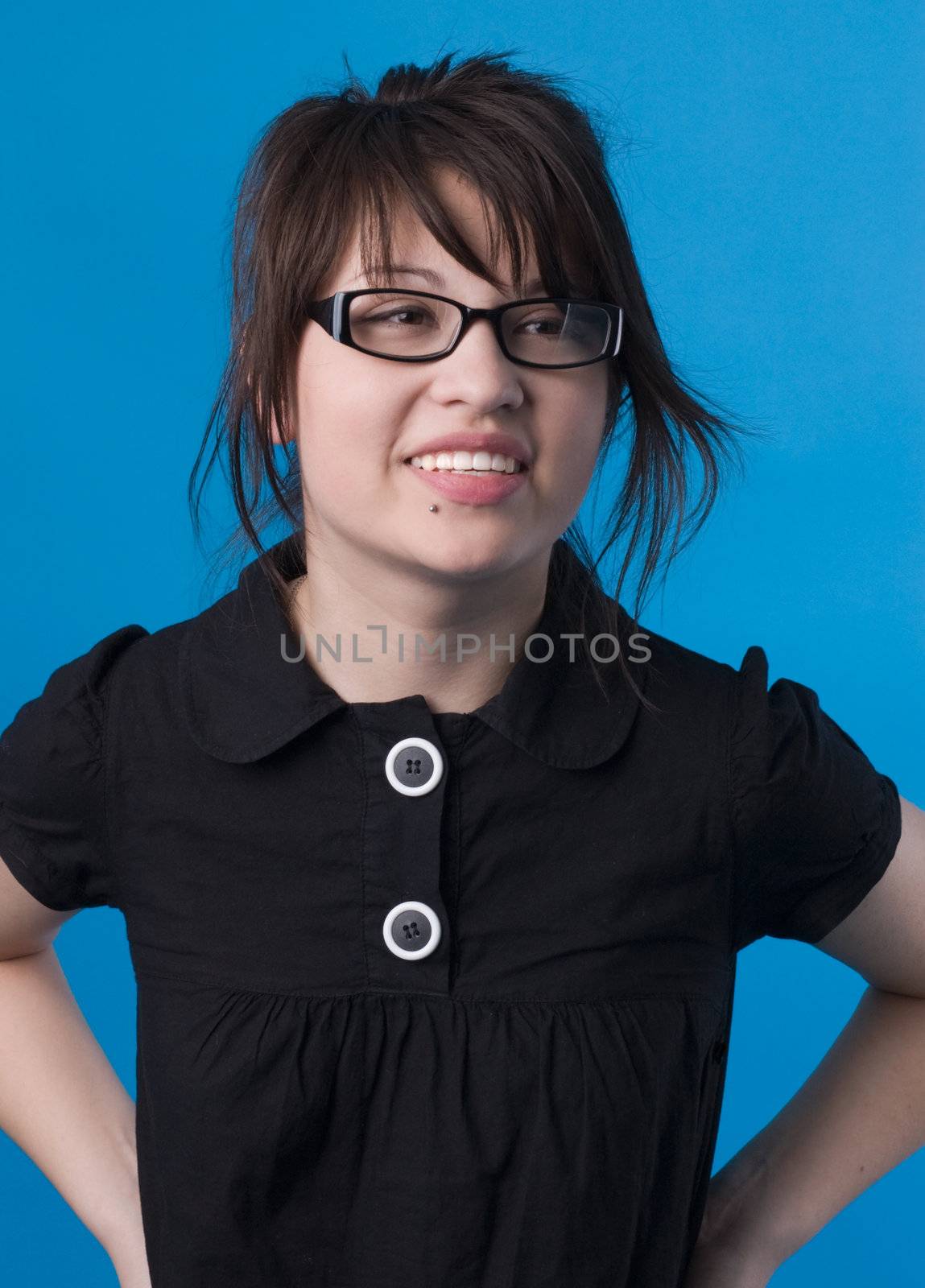 The girl on a dark blue background tries on glasses