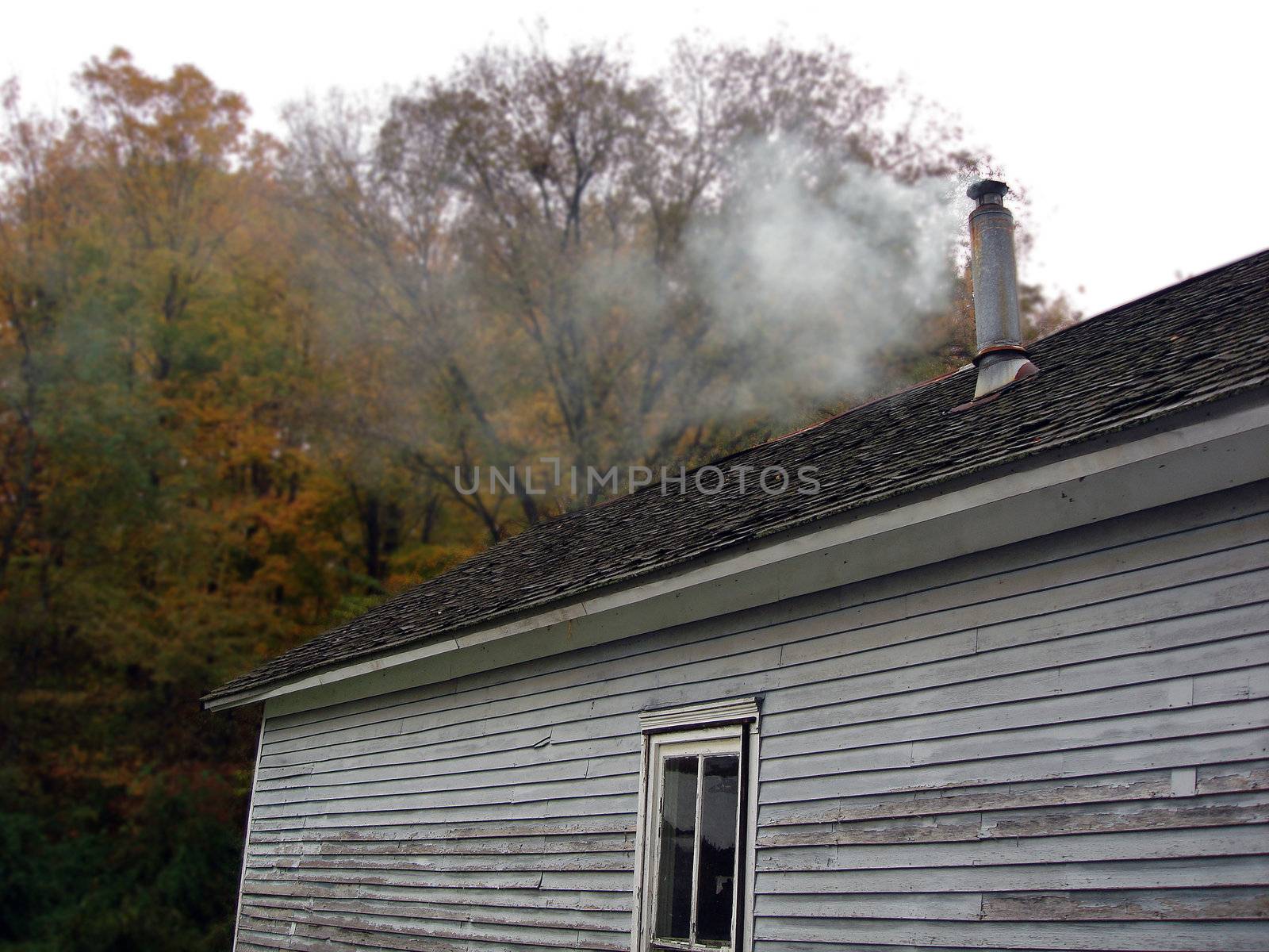 a smoky chimney on top of an old house