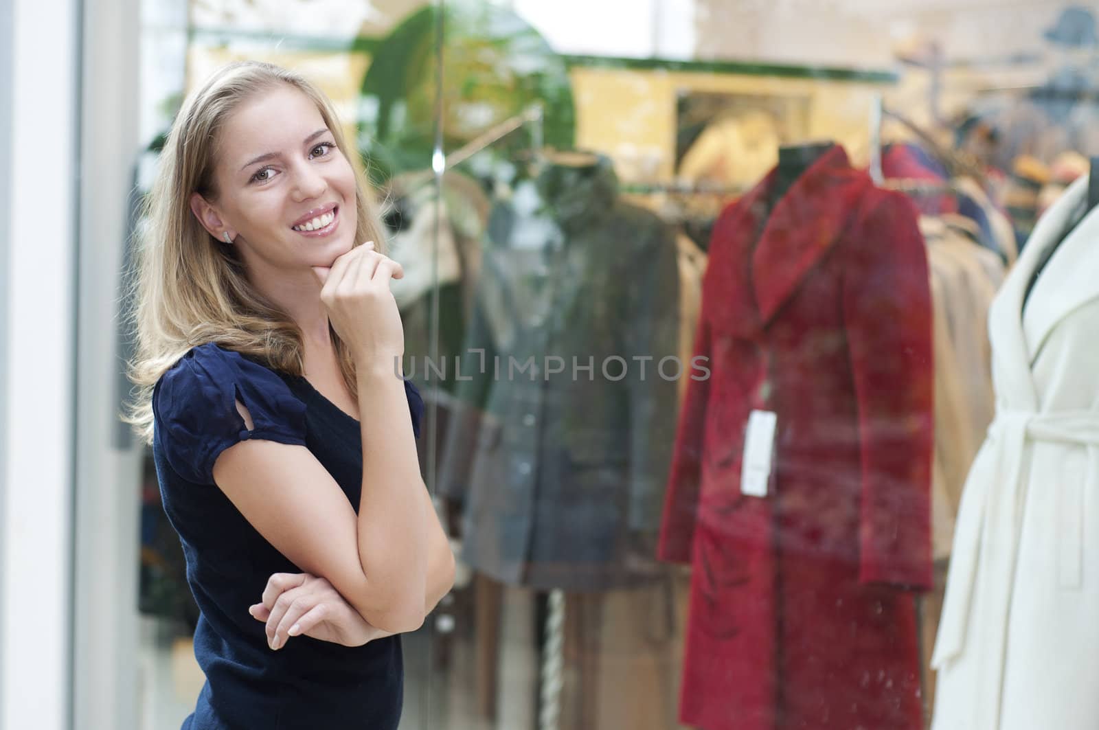 beautiful girl in the store smiling and thinking about shopping during the holidays