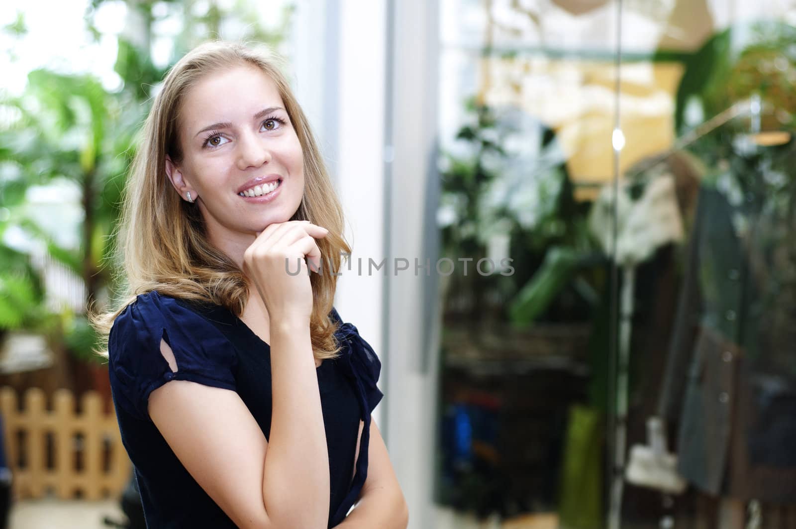 beautiful girl in the store smiling and thinking about shopping during the holidays